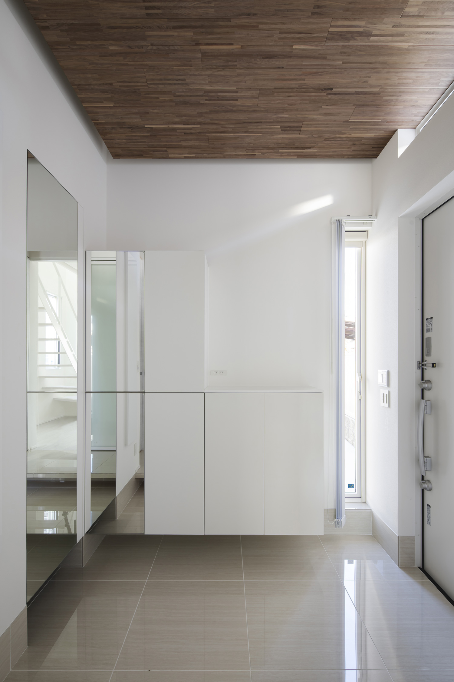 シューズボックスやスリット窓があるタイル張りの床で木目の天井の玄関・デザイン住宅 注文住宅・デザイン住宅建築実例_『CASE656 L x』_玄関