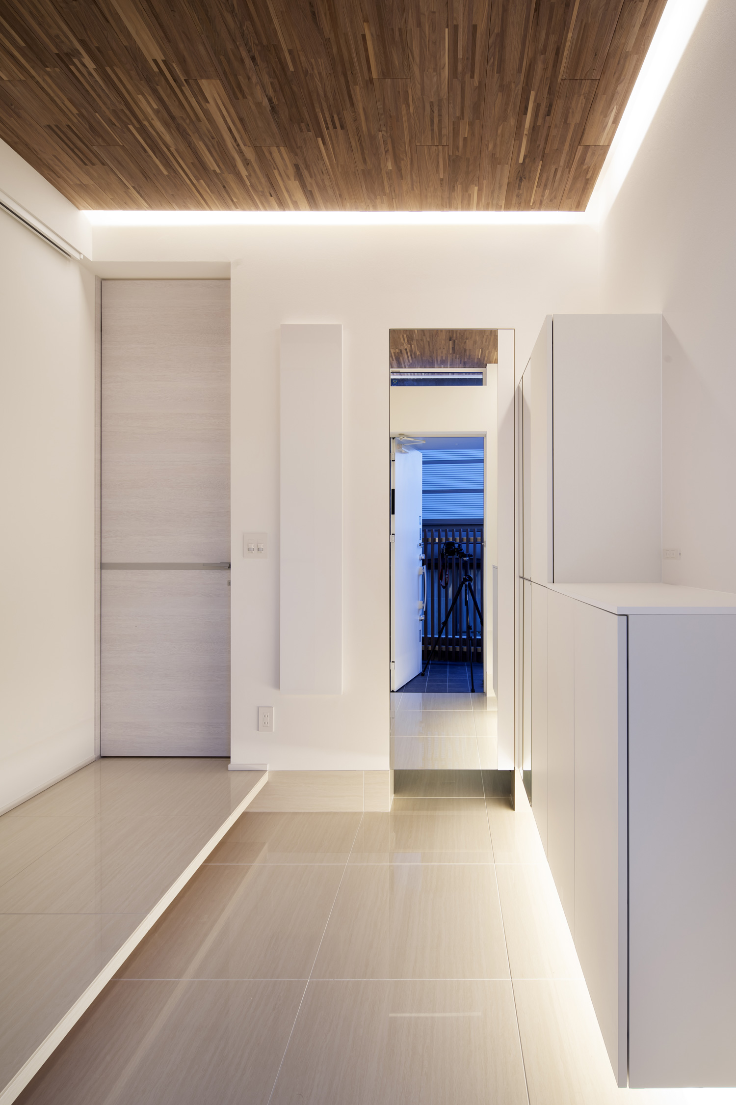 扉の正面に鏡がある、タイル張りの床で木目の天井の玄関・デザイン住宅 注文住宅・デザイン住宅建築実例_『CASE656 L x』_玄関