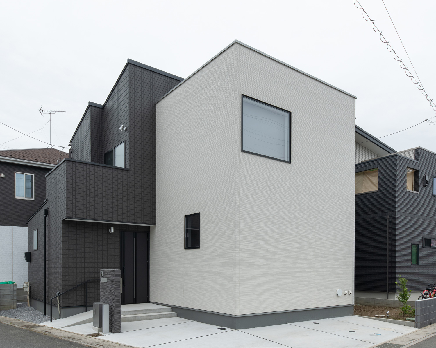 白と黒の外壁で、窓が少ない角地の住宅・デザイン住宅 注文住宅・デザイン住宅建築実例_『CASE658 connecting terminal』_外観