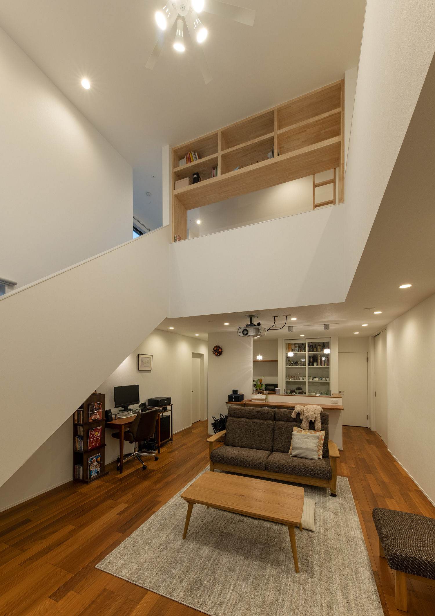 ダウンライトに照らされる、木のインテリアを中心とした吹き抜けのあるLDK・デザイン住宅 注文住宅・デザイン住宅建築実例_『CASE658 connecting terminal』_LDK
