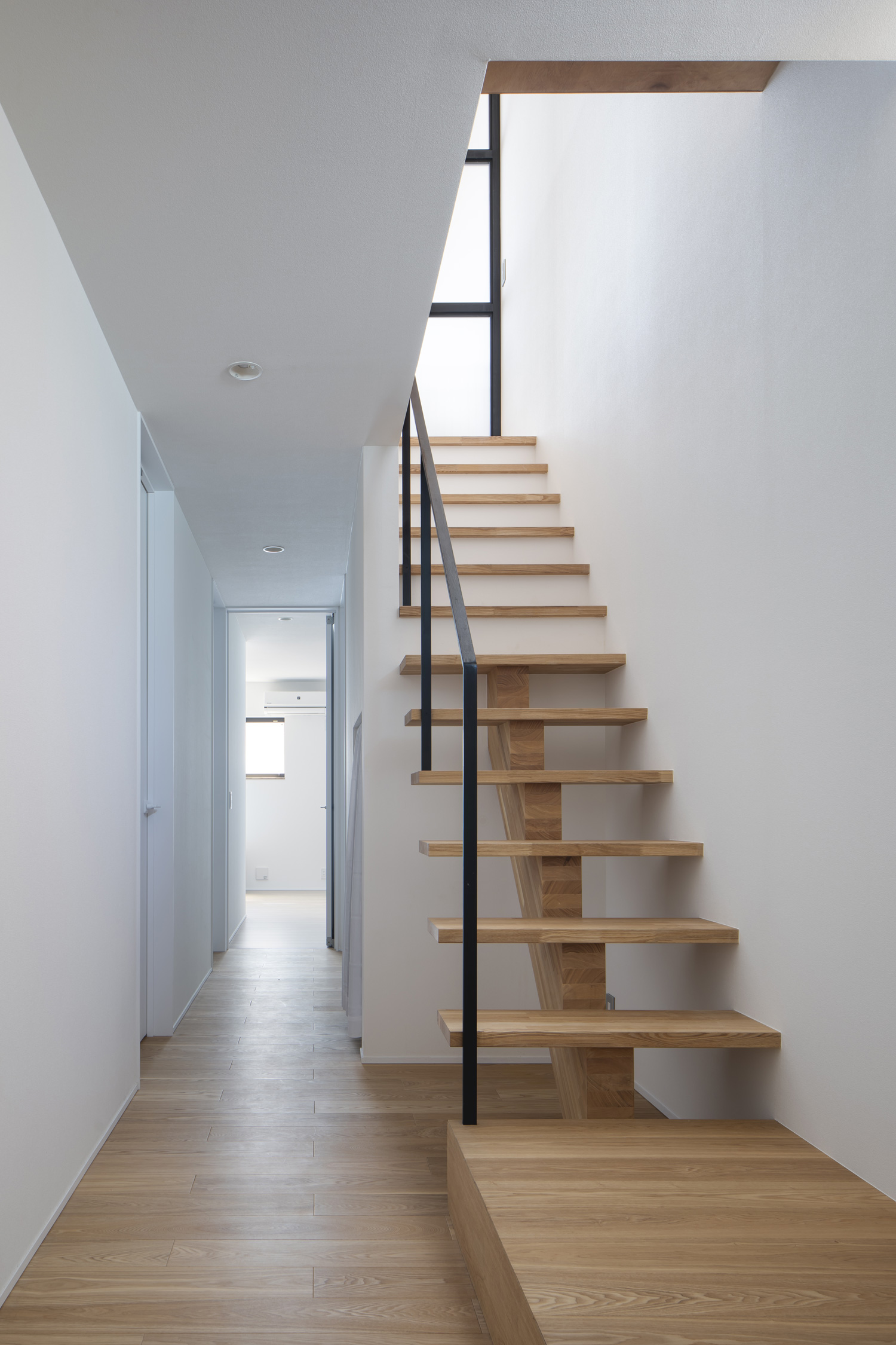 フローリングと同じ素材のスケルトン階段が白い壁に付けられている空間・デザイン住宅 注文住宅・デザイン住宅建築実例_『CASE659 un cube』_階段