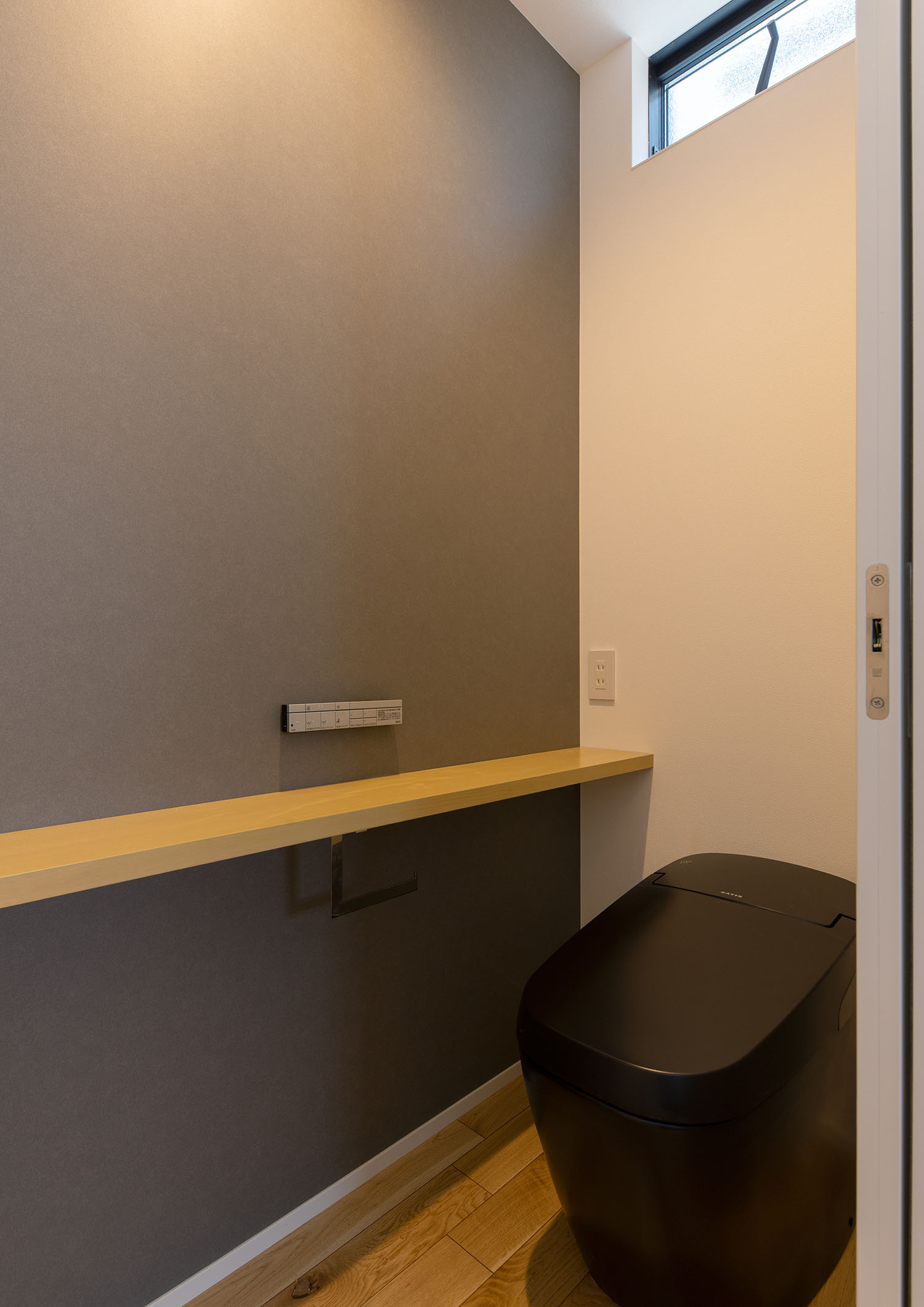 木のカウンターが取り付けられた、黒のタンクレストイレ・デザイン住宅 注文住宅・デザイン住宅建築実例_『CASE660 Marine et grille』_トイレ