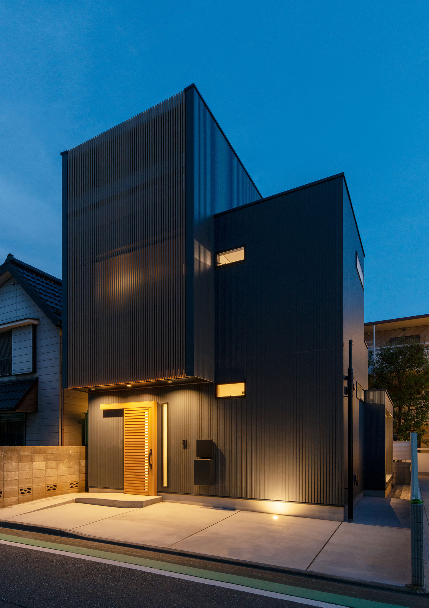駐車スペースの床に取り付けられたダウンライトに外壁が照らされる住宅・デザイン住宅 注文住宅・デザイン住宅建築実例_『CASE660 Marine et grille』_外観