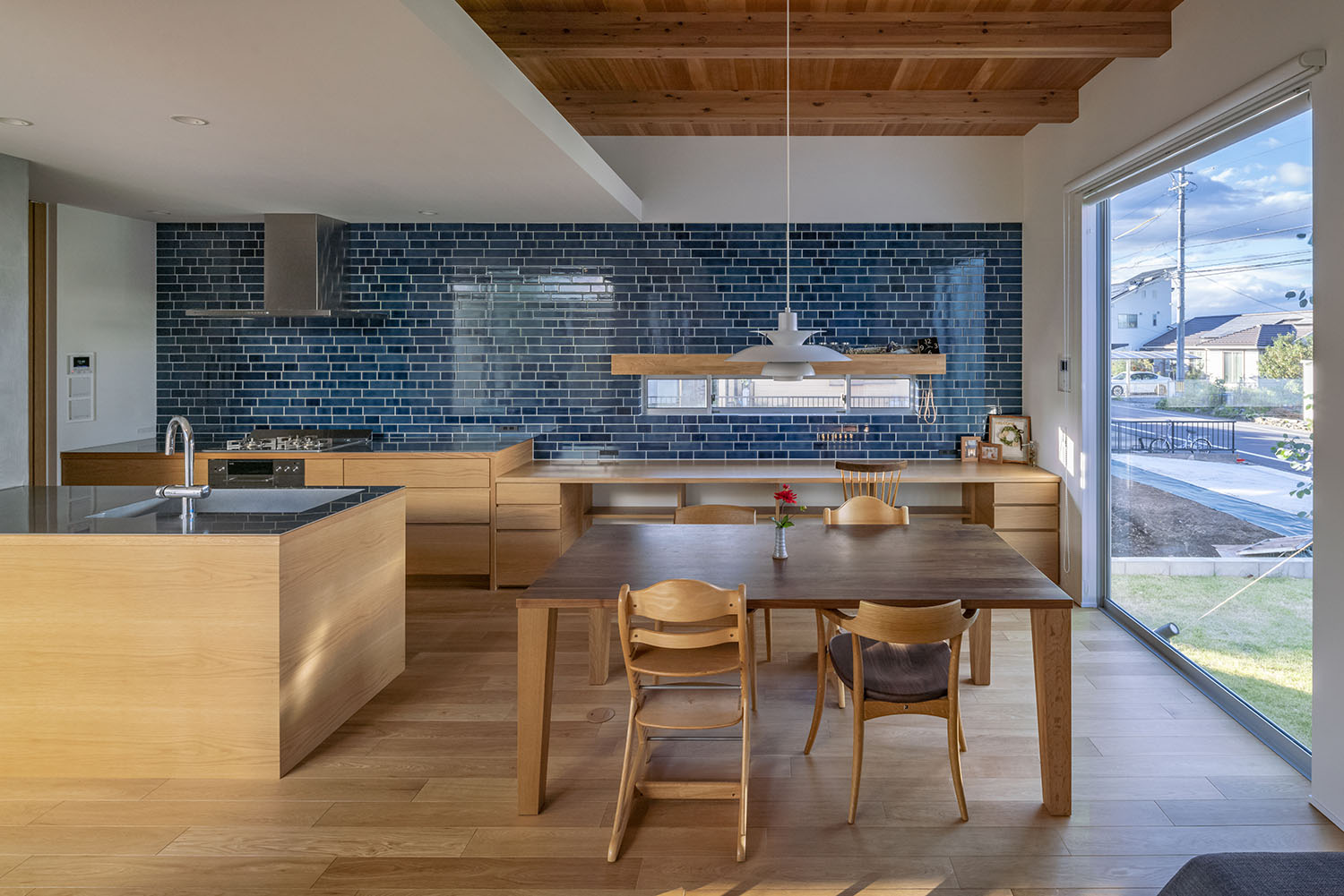 木のインテリアを多く使用した、青いタイルの壁があるLDK・デザイン住宅 注文住宅・デザイン住宅建築実例_『CASE661 環(めぐる)いえ』_LDK