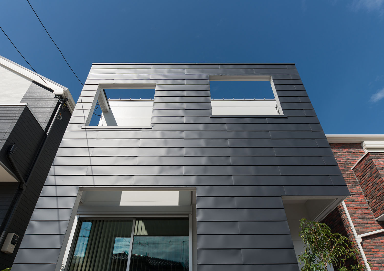 ガルバリウム鋼板の外壁の住宅を正面から見上げた様子・デザイン住宅 注文住宅・デザイン住宅建築実例_『CASE662 まくのいえ』_外観