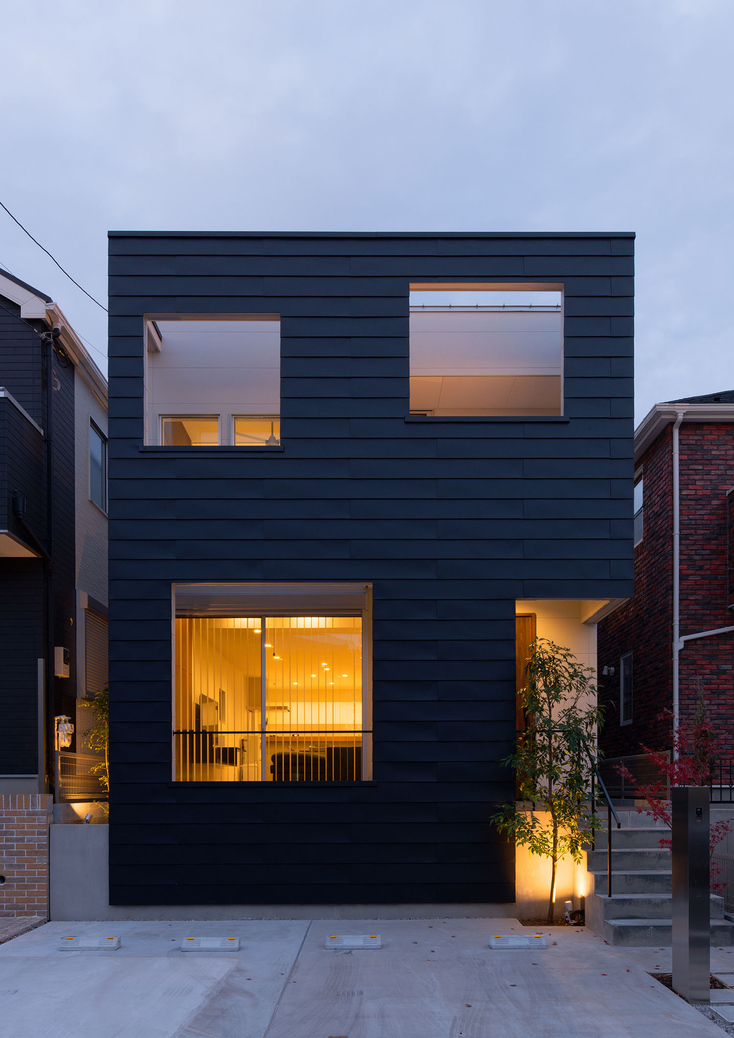 開口部から室内の光が見えるガルバリウム鋼板の外壁の住宅・デザイン住宅 注文住宅・デザイン住宅建築実例_『CASE662 まくのいえ』_外観