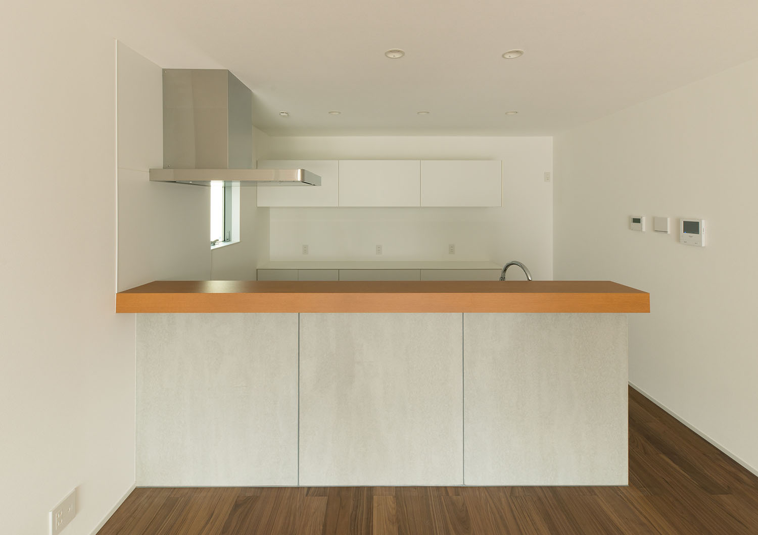 腰壁と木のカウンターが取り付けられたペニンシュラキッチン・デザイン住宅 注文住宅・デザイン住宅建築実例_『CASE662 まくのいえ』_キッチン