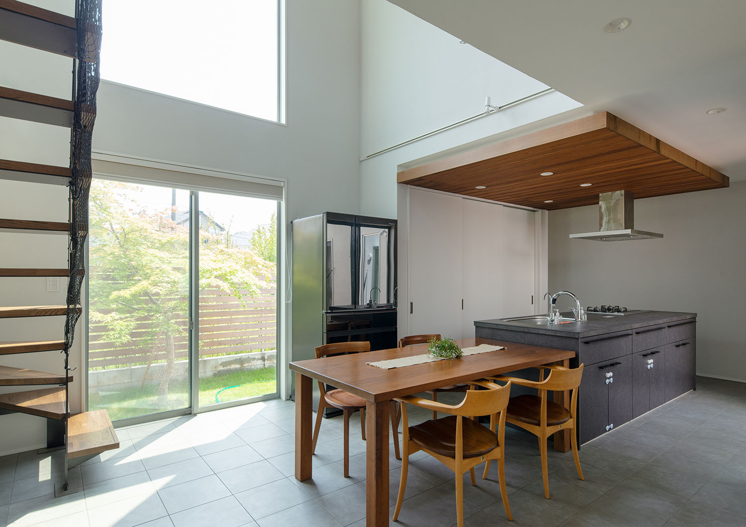 四人掛けの木のダイニングテーブルと並んだグレーのアイランドキッチン・デザイン住宅 注文住宅・デザイン住宅建築実例_『CASE663 シークエンス』_LDK