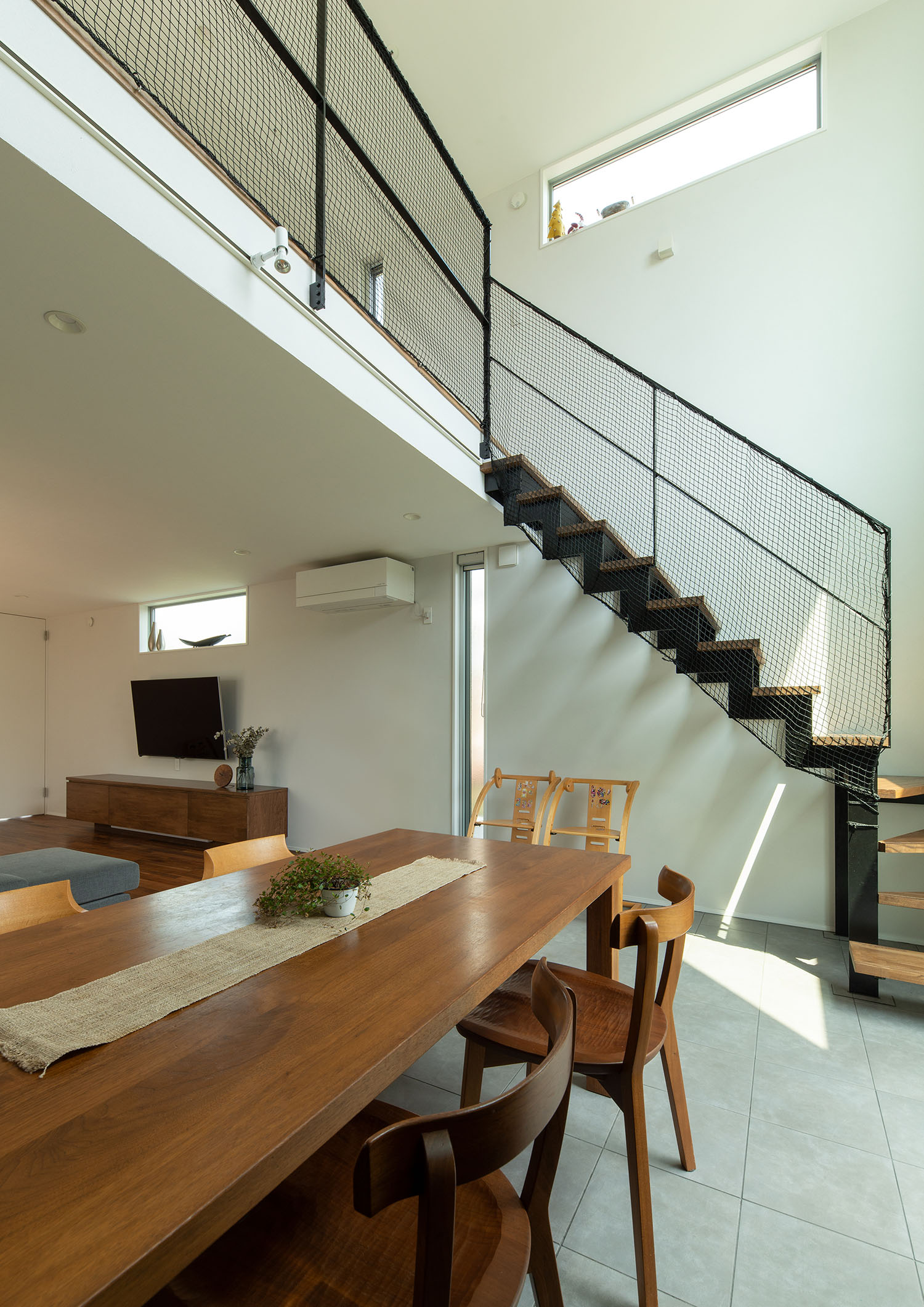 手摺のついた二階とダイニングが吹き抜けを通じて繋がる様子・デザイン住宅 注文住宅・デザイン住宅建築実例_『CASE663 シークエンス』_LDK