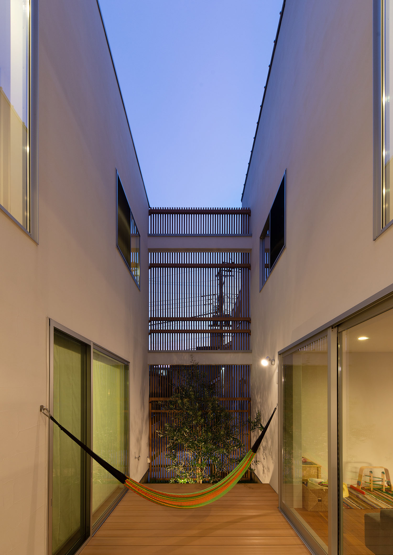 スポットライトが壁に付けられた、ハンモックのあるウッドデッキの中庭・デザイン住宅 注文住宅・デザイン住宅建築実例_『CASE663 シークエンス』_中庭