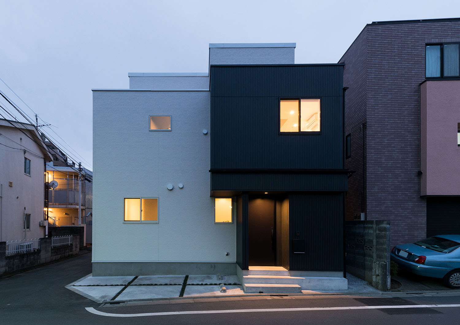 窓から光が漏れる白と黒の外壁の住宅・デザイン住宅 注文住宅・デザイン住宅建築実例_『CASE664 『BOX in BOX』』_外観