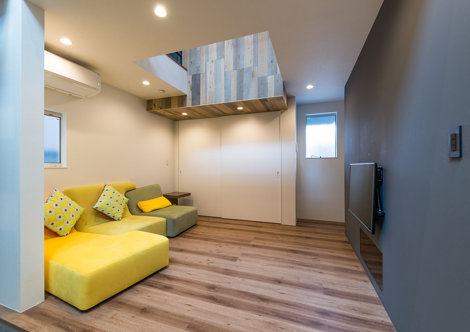 黒のアクセントクロスがあり、天井の一部が吹き抜けになっているフローリングのLDK・デザイン住宅 注文住宅・デザイン住宅建築実例_『CASE664 『BOX in BOX』』_LDK