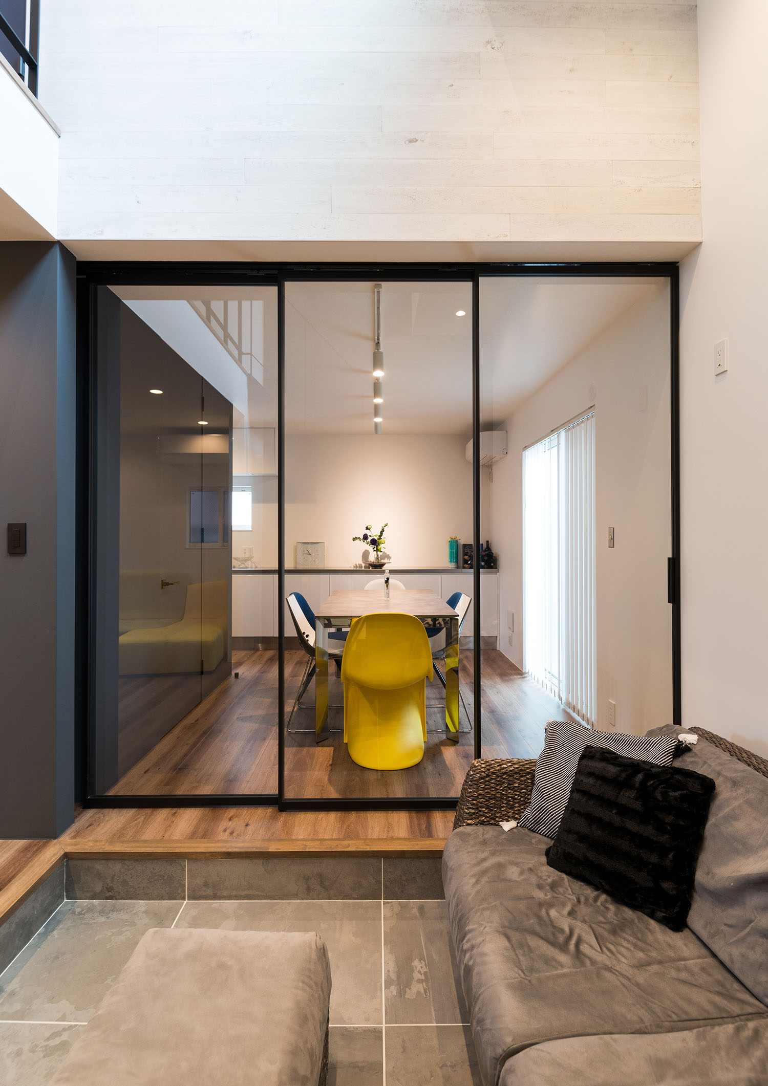 タイルのインナーテラスとフローリングのダイニングがガラス扉で仕切られている様子・デザイン住宅 注文住宅・デザイン住宅建築実例_『CASE664 『BOX in BOX』』_LDK