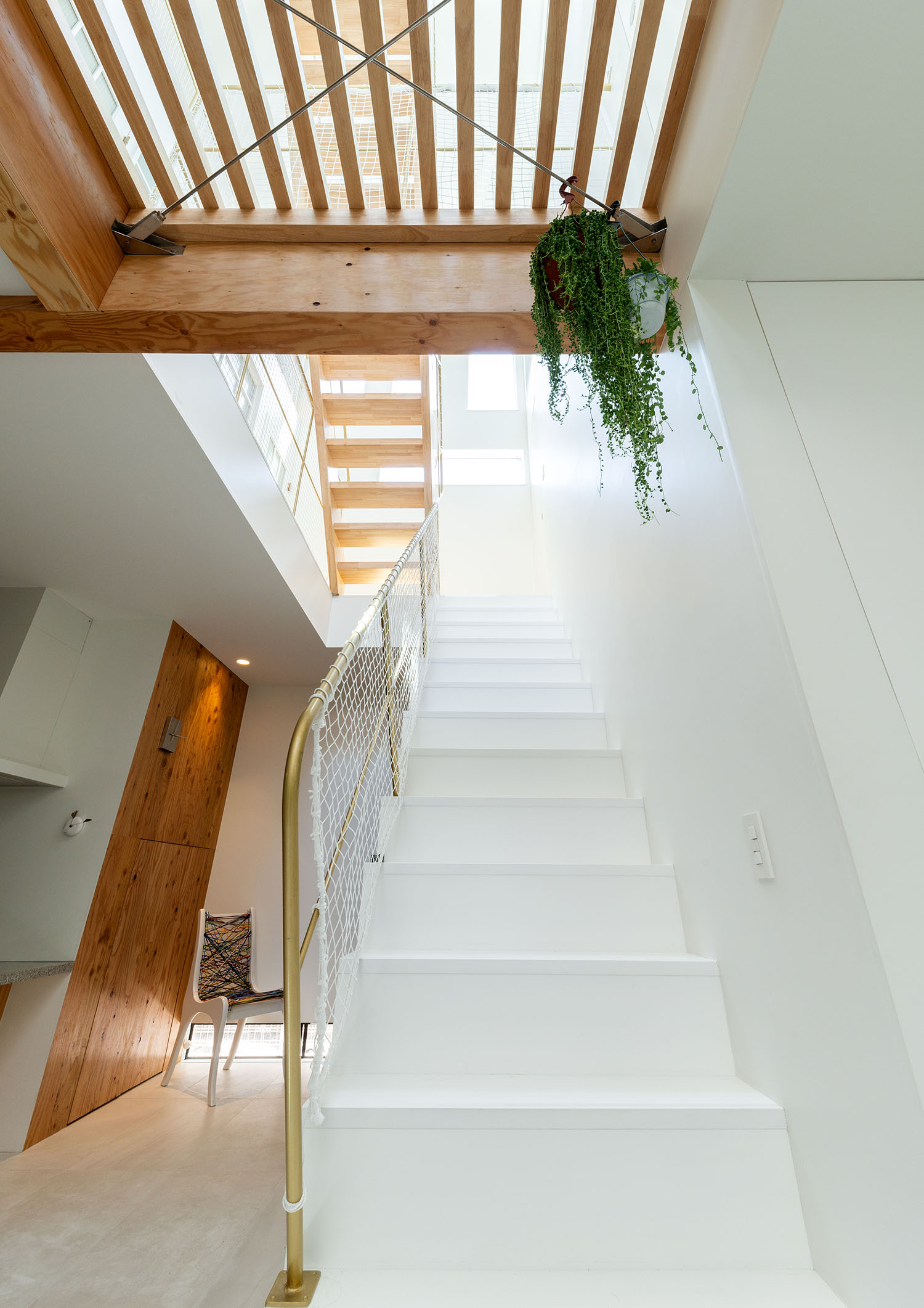 白い箱型階段のある空間の上部がルーバーの天井になっている様子・デザイン住宅 注文住宅・デザイン住宅建築実例_『CASE665 LUCE』_階段