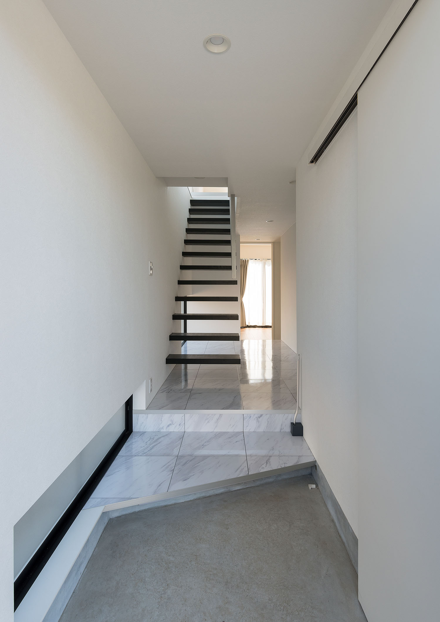 大理石風の玄関からスケルトン階段に繋がる様子・デザイン住宅 注文住宅・デザイン住宅建築実例_『CASE667 コントラスト』_玄関