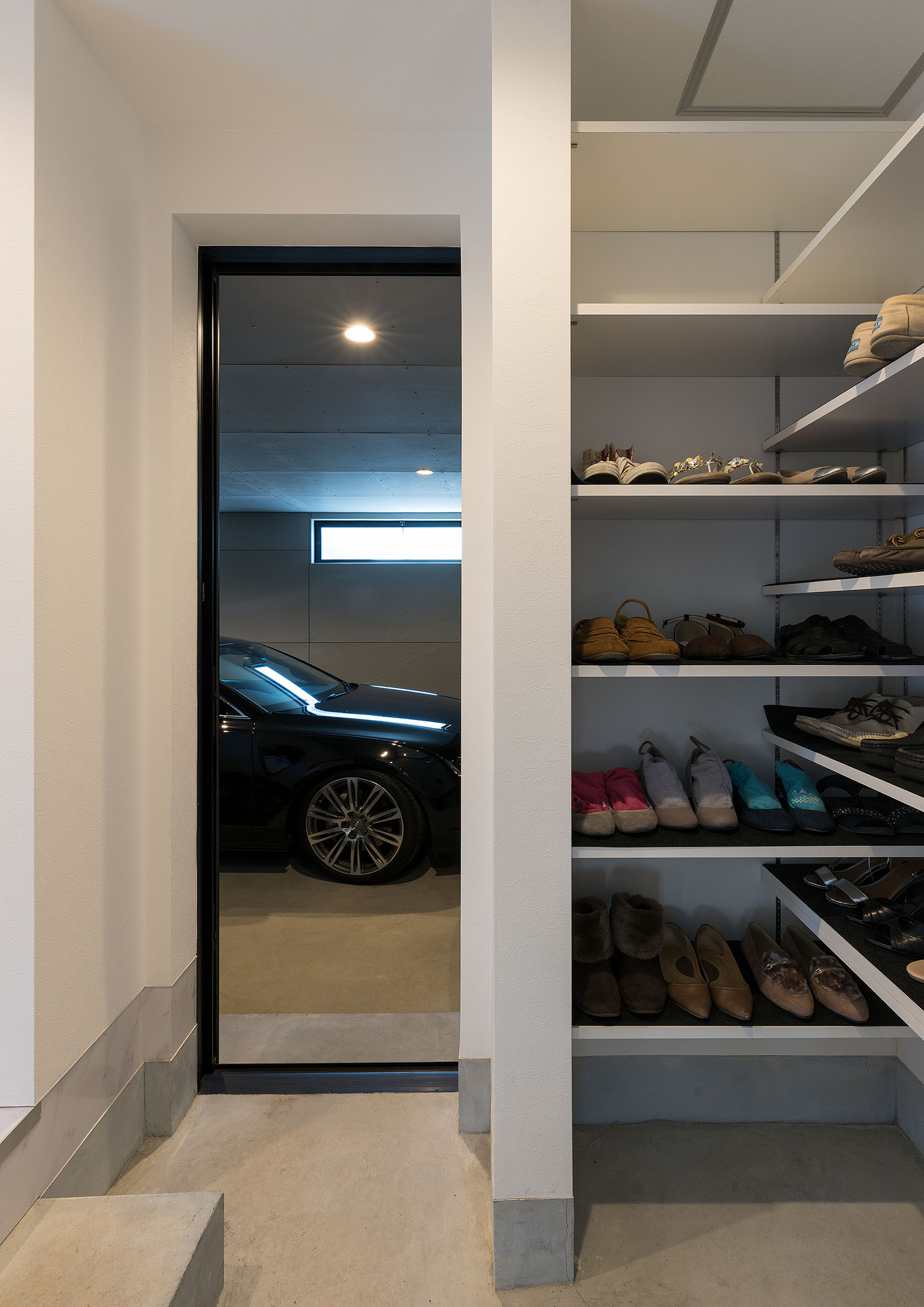 シューズインクローゼットと、ガレージが見えるスリット窓がある玄関・デザイン住宅 注文住宅・デザイン住宅建築実例_『CASE667 コントラスト』_玄関