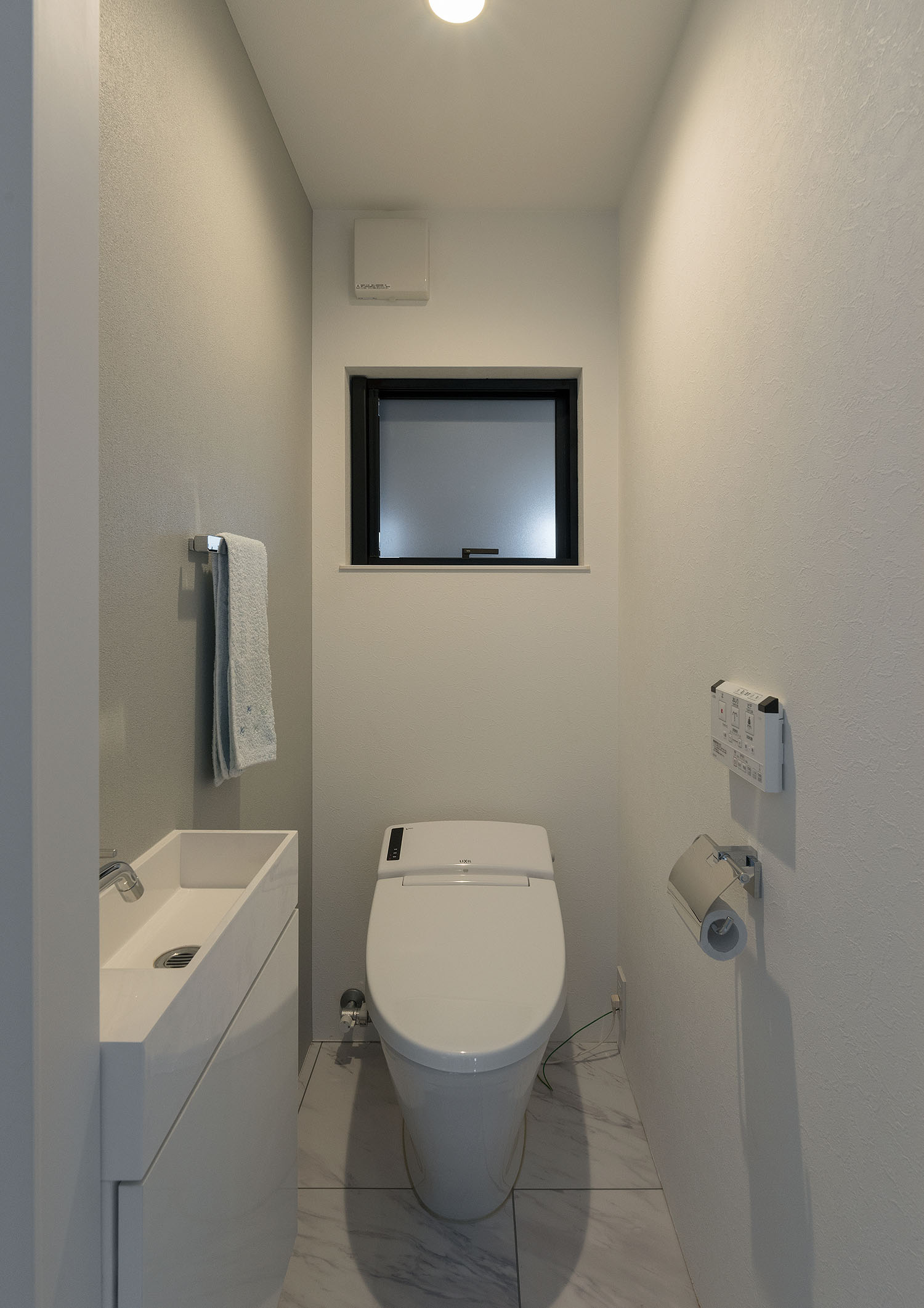 薄型手洗いがある大理石風の床のトイレ・デザイン住宅 注文住宅・デザイン住宅建築実例_『CASE667 コントラスト』_トイレ