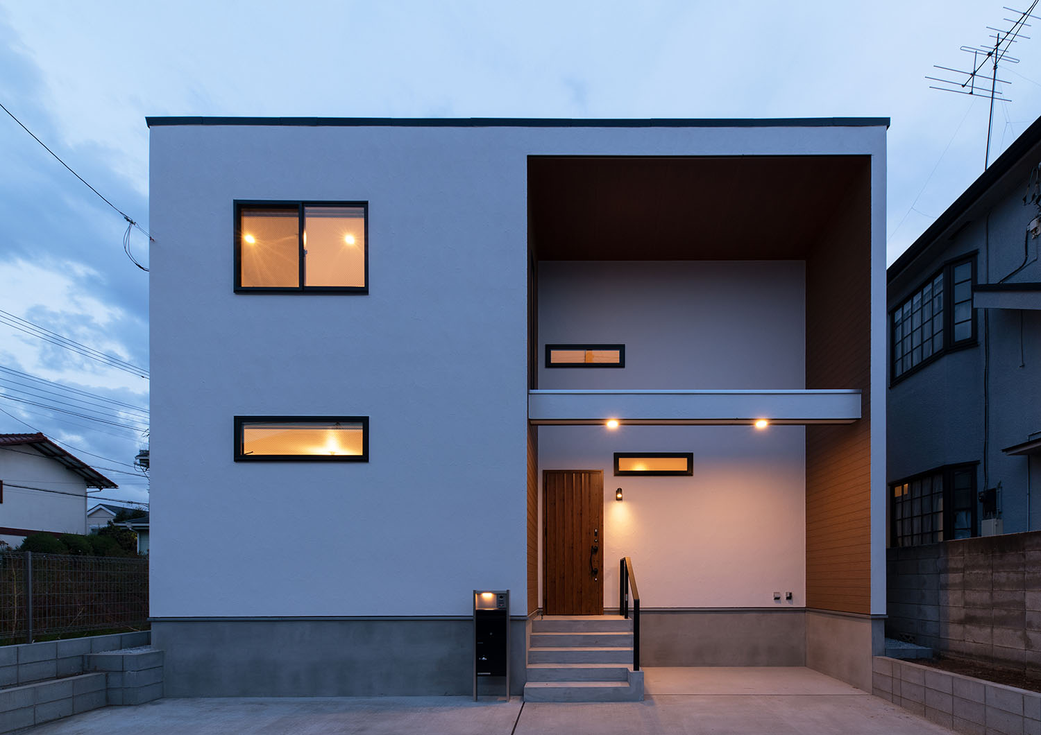 玄関ポーチが照明で照らされ、窓から光が漏れる住宅の外観・デザイン住宅 注文住宅・デザイン住宅建築実例_『CASE668 square up』_外観