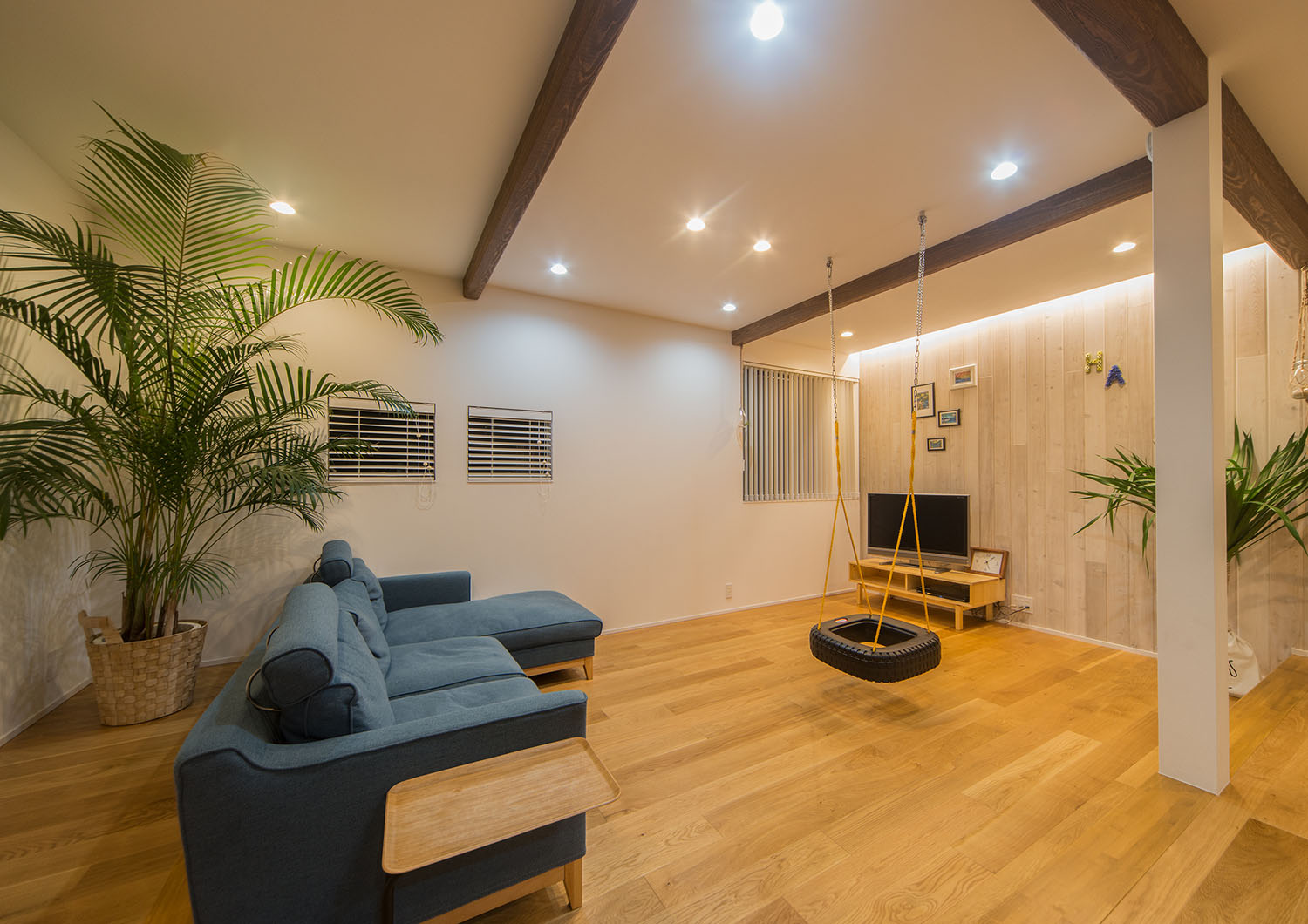 ダウンライトに照らされた、観葉植物やタイヤのブランコがあるLDK・Gardenのある家 注文住宅・デザイン住宅建築実例_『CASE674 Gardenのある家』_LDK
