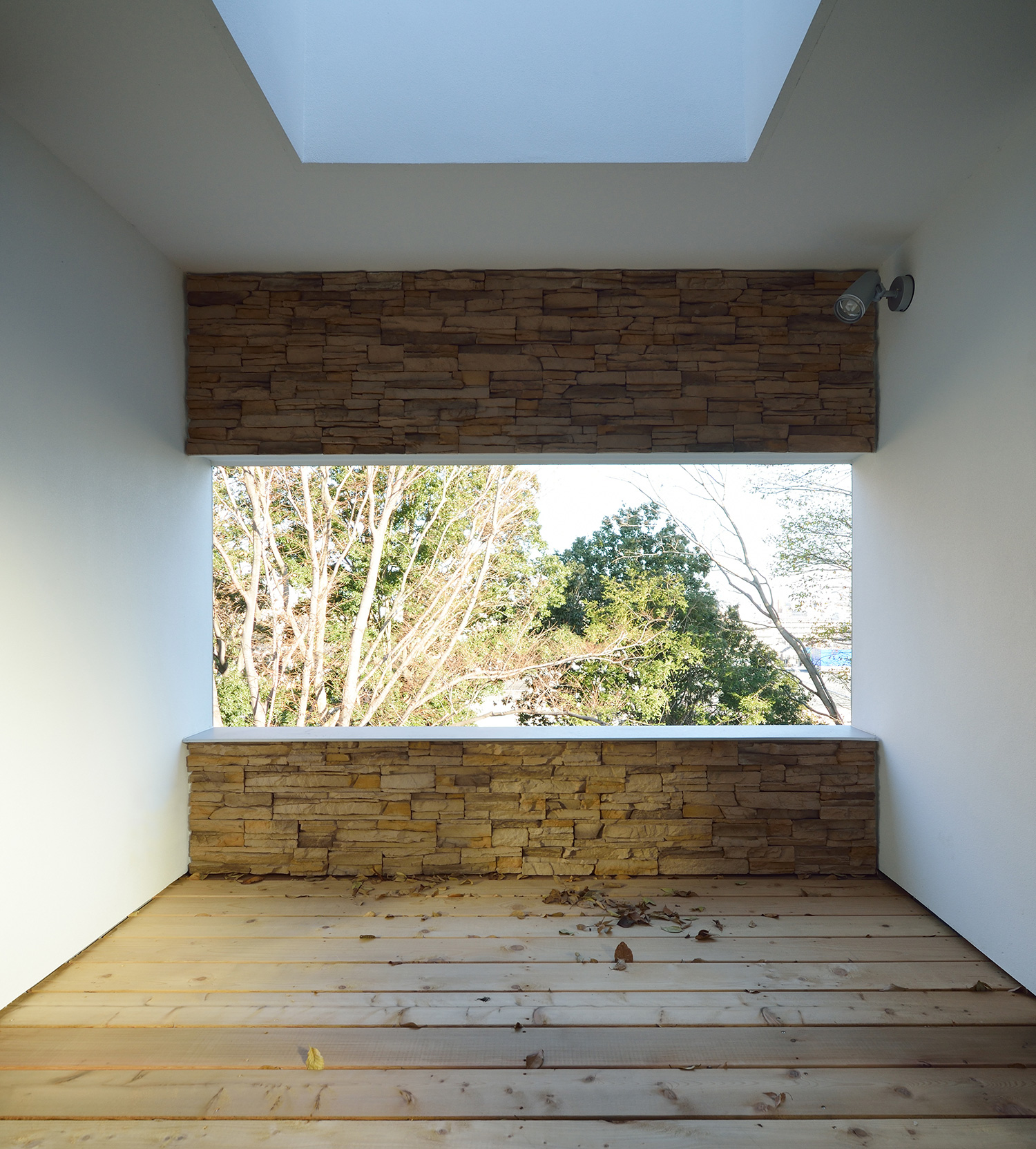 開口部の上下がタイルのアクセントウォールになっているウッドデッキの中庭・デザイン住宅 注文住宅・デザイン住宅建築実例_『CASE676 箱を包む小屋裏』_テラス・バルコニー