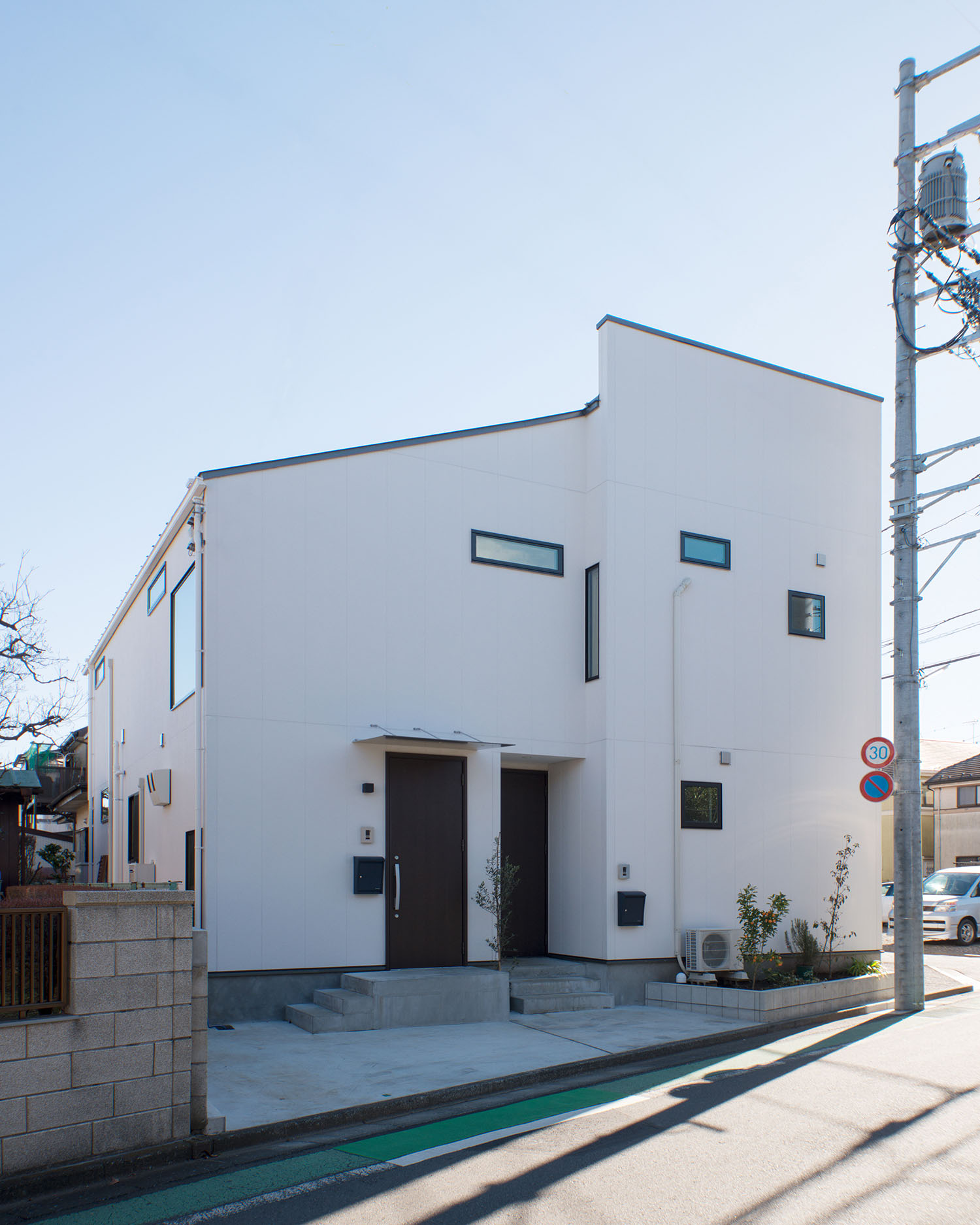 白い外壁に小さな窓やスリット窓が設けられた住宅の外観・デザイン住宅 注文住宅・デザイン住宅建築実例_『CASE677 中庭が繋ぐ家族の気配』_外観