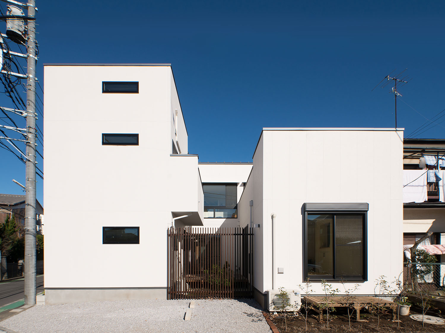 ルーバーの目隠しが立てられた中庭のある、白い外壁の住宅・デザイン住宅 注文住宅・デザイン住宅建築実例_『CASE677 中庭が繋ぐ家族の気配』_外観