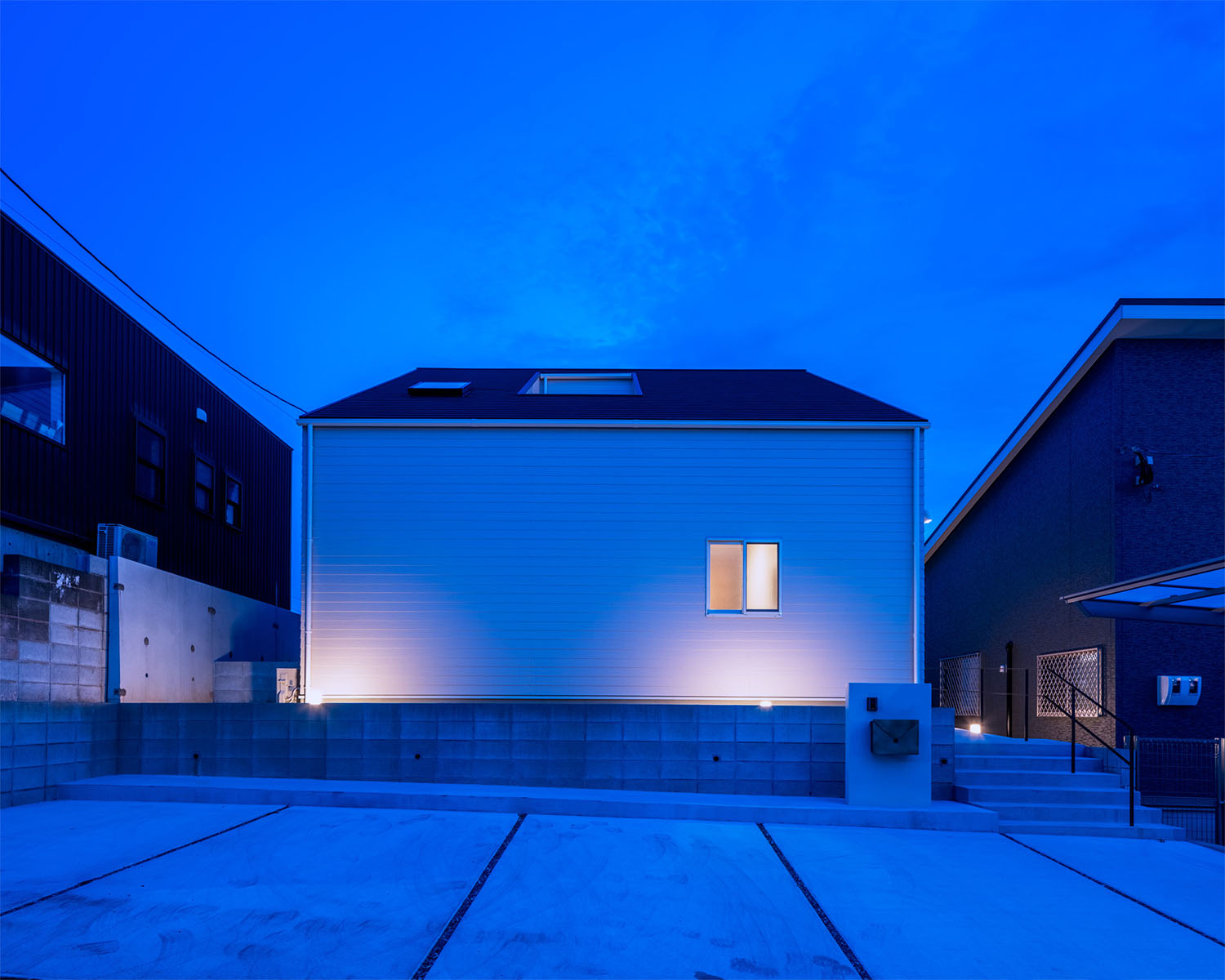 屋外照明によって照らされた、小さな窓が一つある住宅の外観・デザイン住宅 注文住宅・デザイン住宅建築実例_『CASE679 だんだんのいえ』_外観