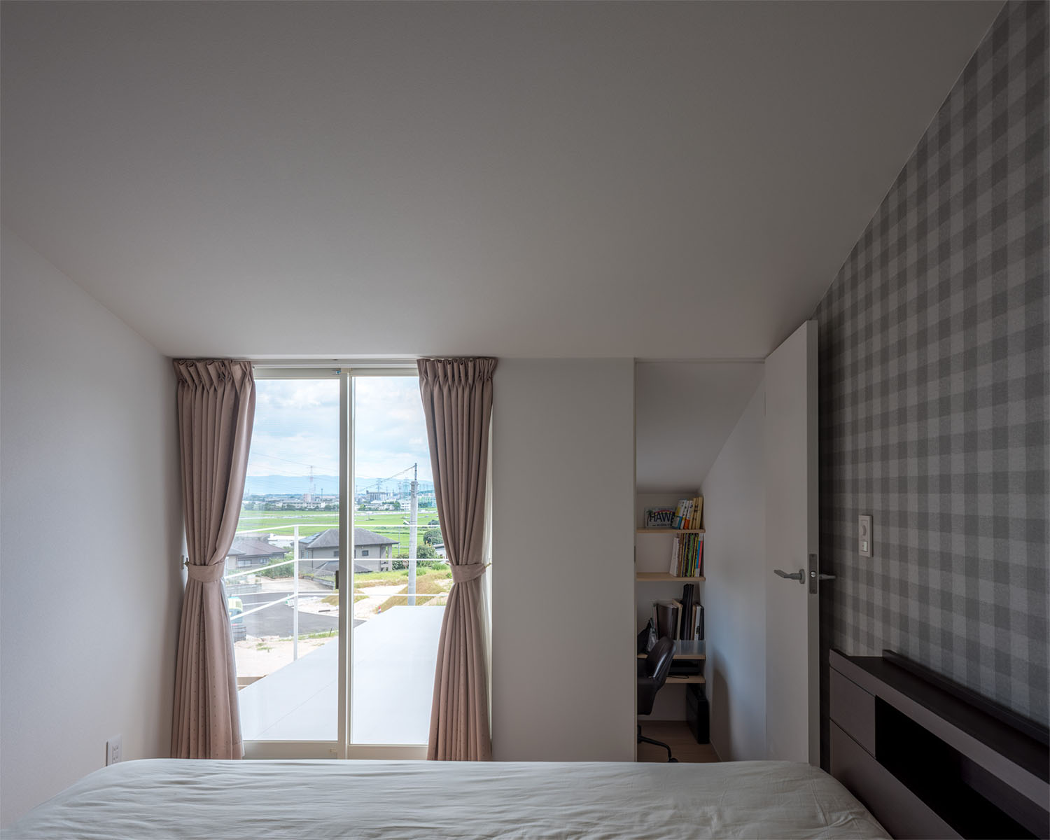 チェックのアクセントクロスがあり、外が見える窓や書斎がある寝室・デザイン住宅 注文住宅・デザイン住宅建築実例_『CASE679 だんだんのいえ』_寝室