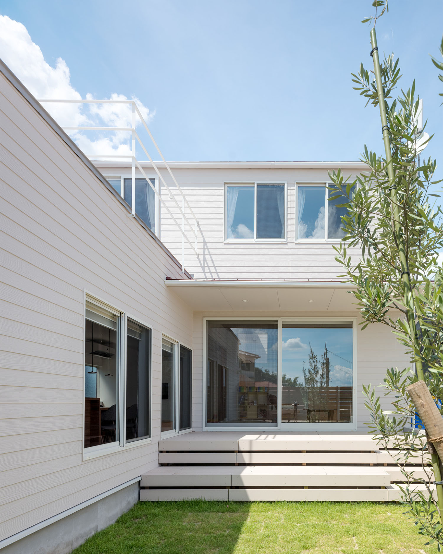 芝生の庭に面して窓が多く取り付けられた白い外壁の住宅・デザイン住宅 注文住宅・デザイン住宅建築実例_『CASE679 だんだんのいえ』_外観