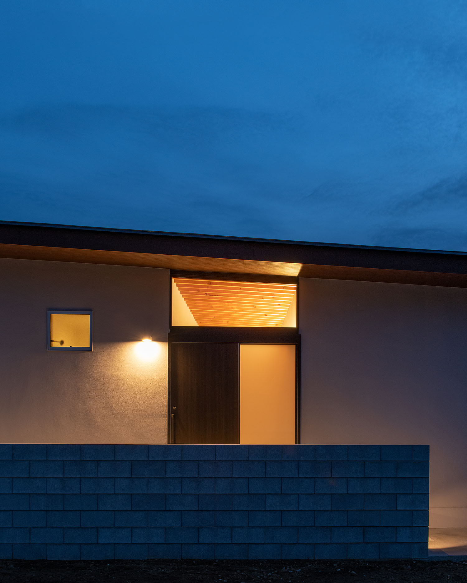 小さな窓と、天井まで窓が設けられた玄関部分から光が漏れる様子・デザイン住宅 注文住宅・デザイン住宅建築実例_『CASE680 寛か(くつろか)な平屋』_外観