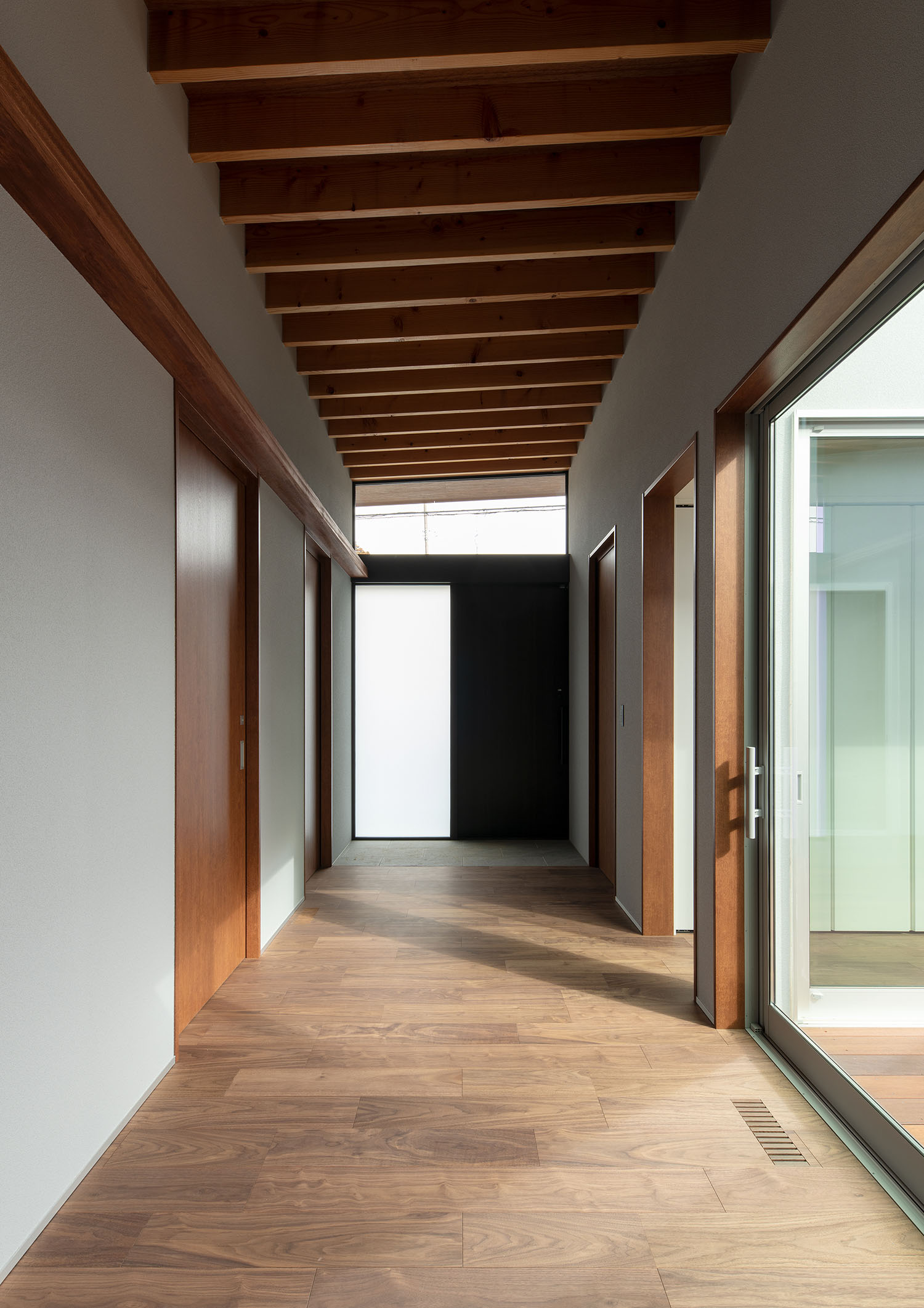 フローリングで梁見せ天井になっている、窓に面した廊下・デザイン住宅 注文住宅・デザイン住宅建築実例_『CASE680 寛か(くつろか)な平屋』_玄関