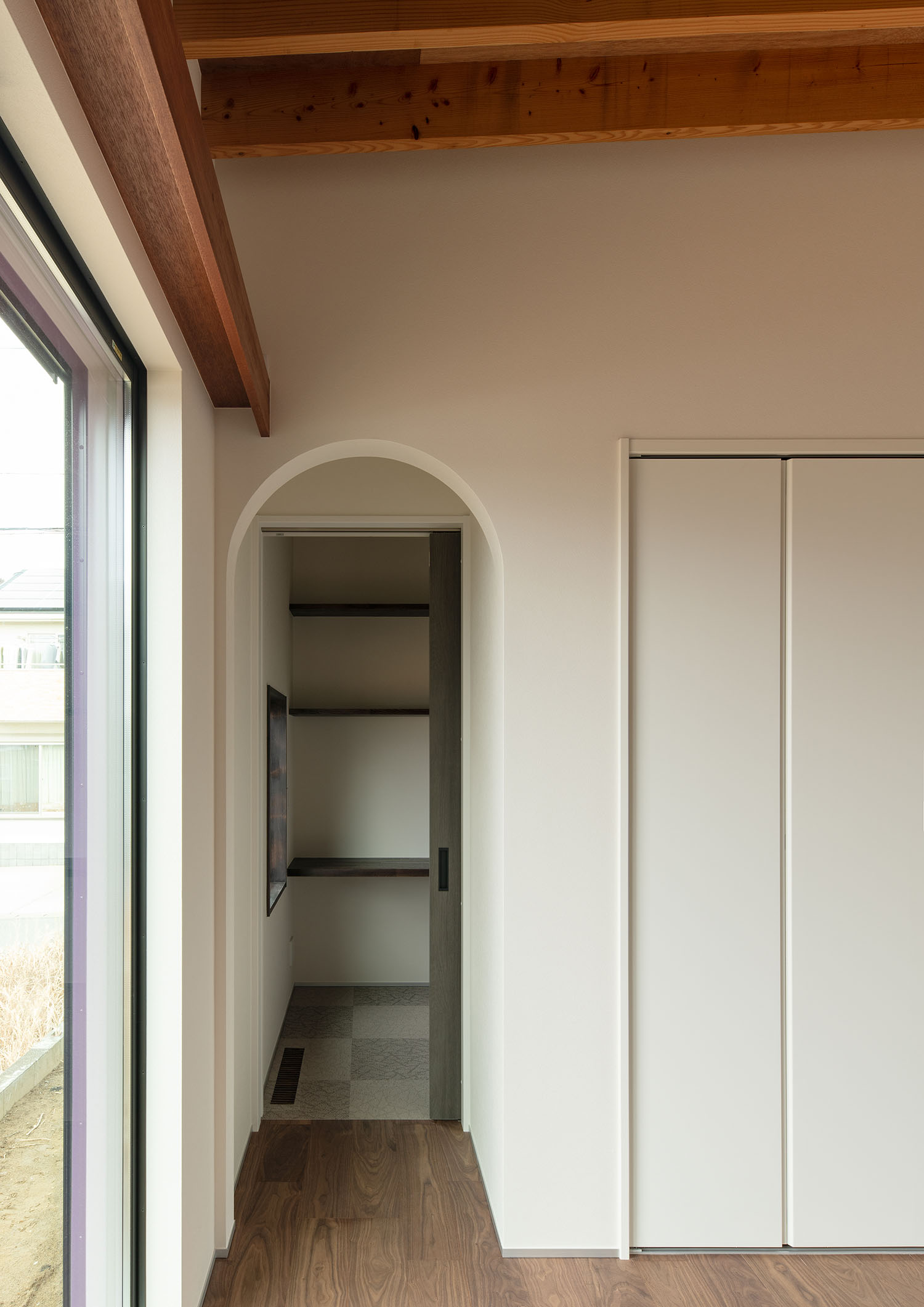 アーチ壁の奥に収納棚が設けられている様子・デザイン住宅 注文住宅・デザイン住宅建築実例_『CASE680 寛か(くつろか)な平屋』_寝室