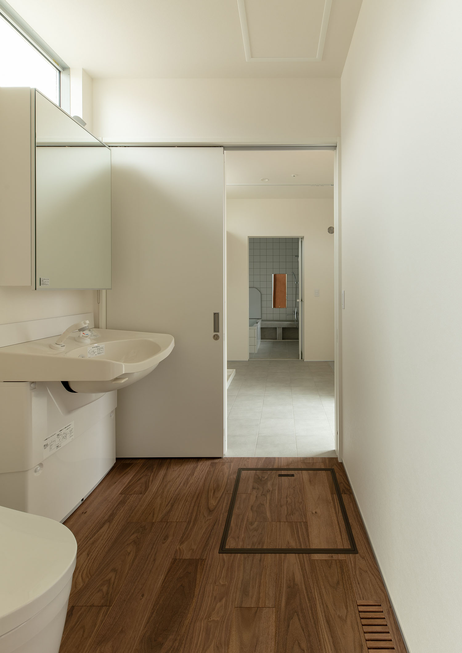 フローリングの床で、白を基調とした洗面所・デザイン住宅 注文住宅・デザイン住宅建築実例_『CASE680 寛か(くつろか)な平屋』_浴室・洗面所