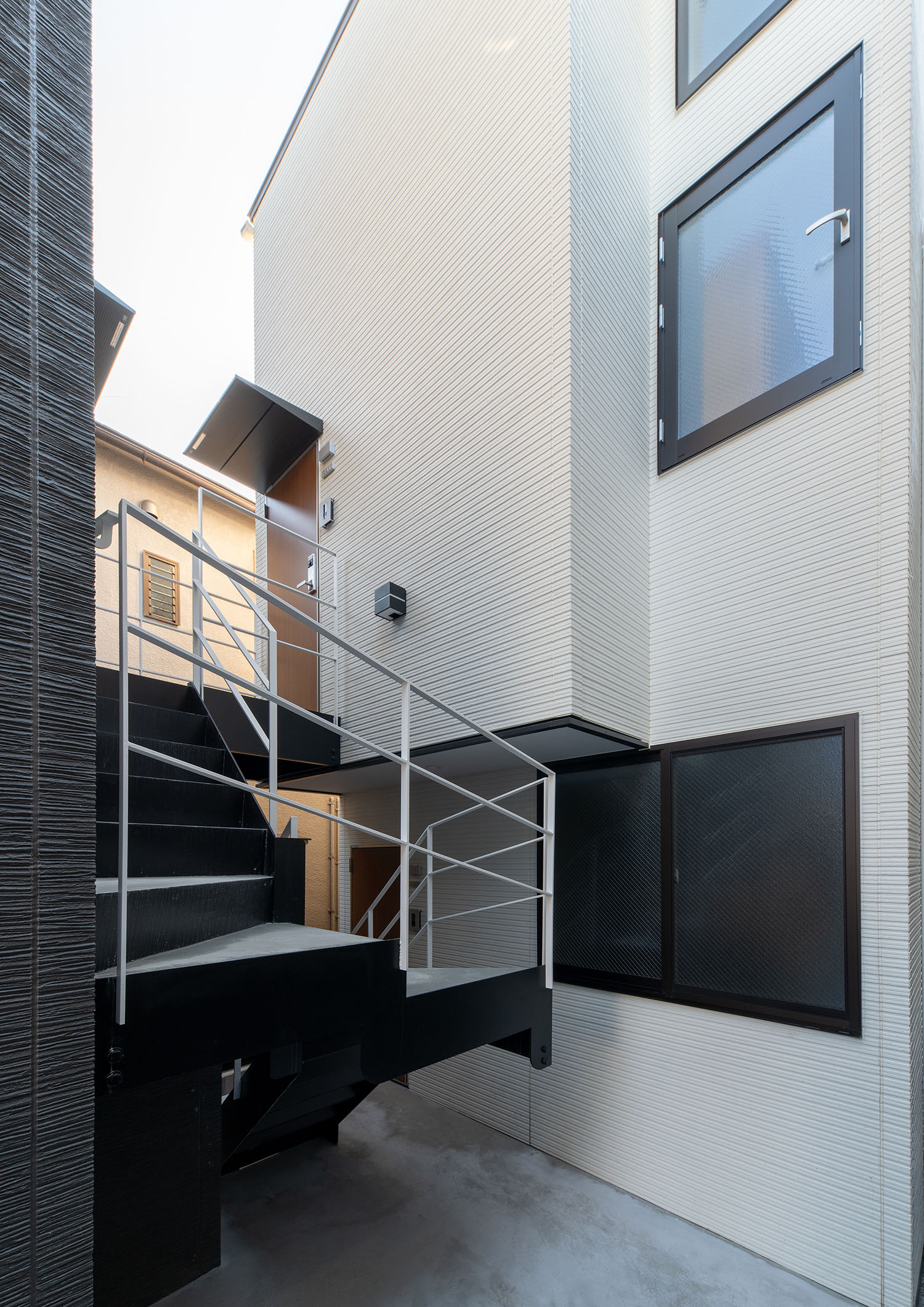 螺旋の外階段がある、白い外壁の建物・賃貸併用住宅 注文住宅・デザイン住宅建築実例_『CASE681 penche' 「パンシェ」の家』_外観