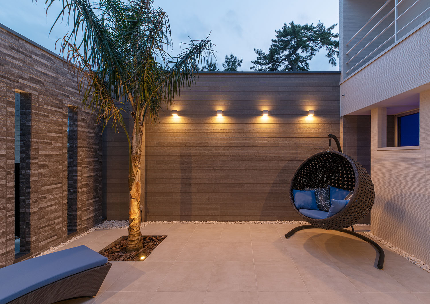 壁に間接照明が取り付けられた、ヤシの木やハンモックチェアがある中庭・デザイン住宅 注文住宅・デザイン住宅建築実例_『CASE682 Casa de Resort』_中庭