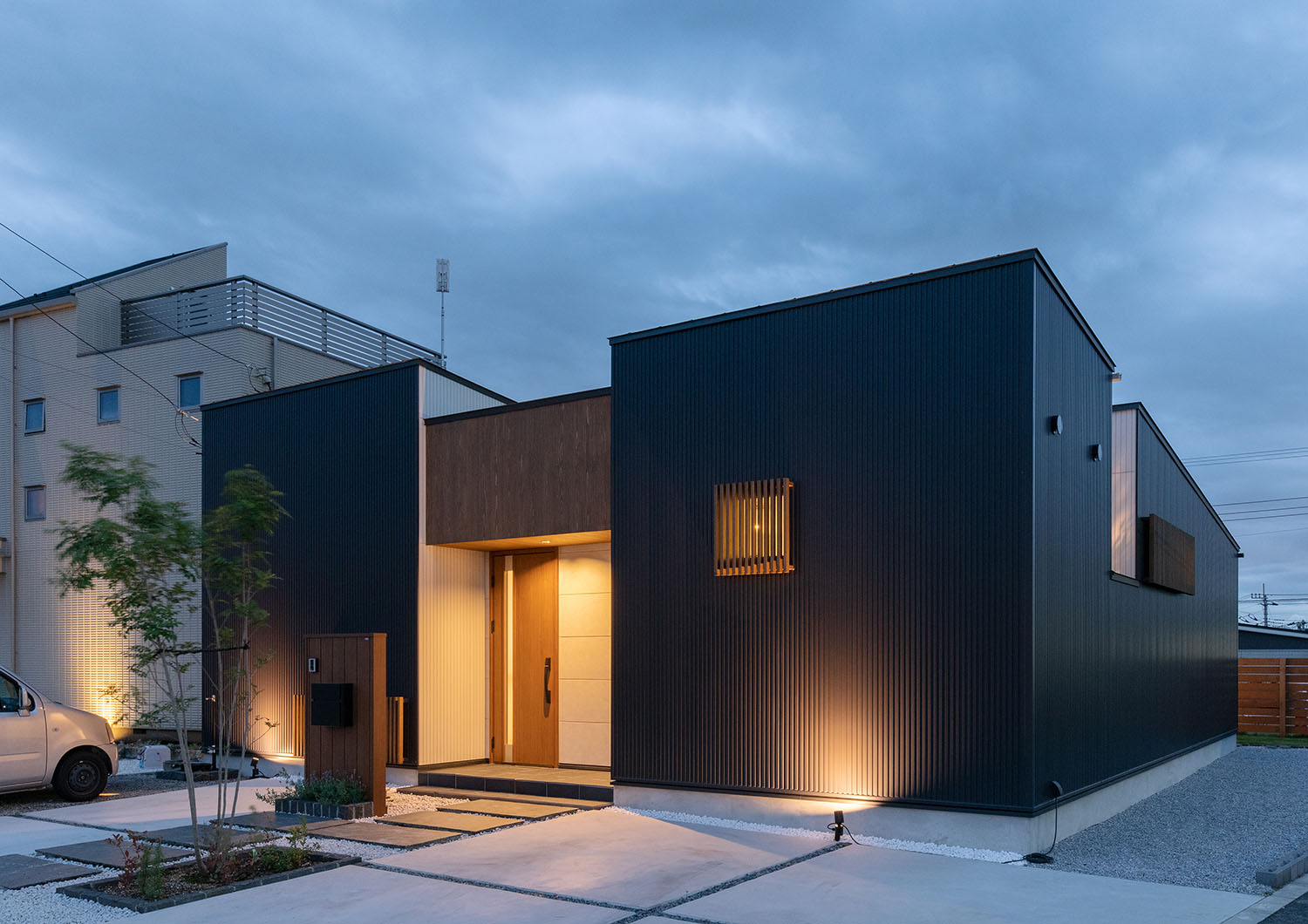 屋外照明によって照らされるキューブ状の外観を斜めから見た様子・デザイン住宅 注文住宅・デザイン住宅建築実例_『CASE683 丘の上のハウス』_外観