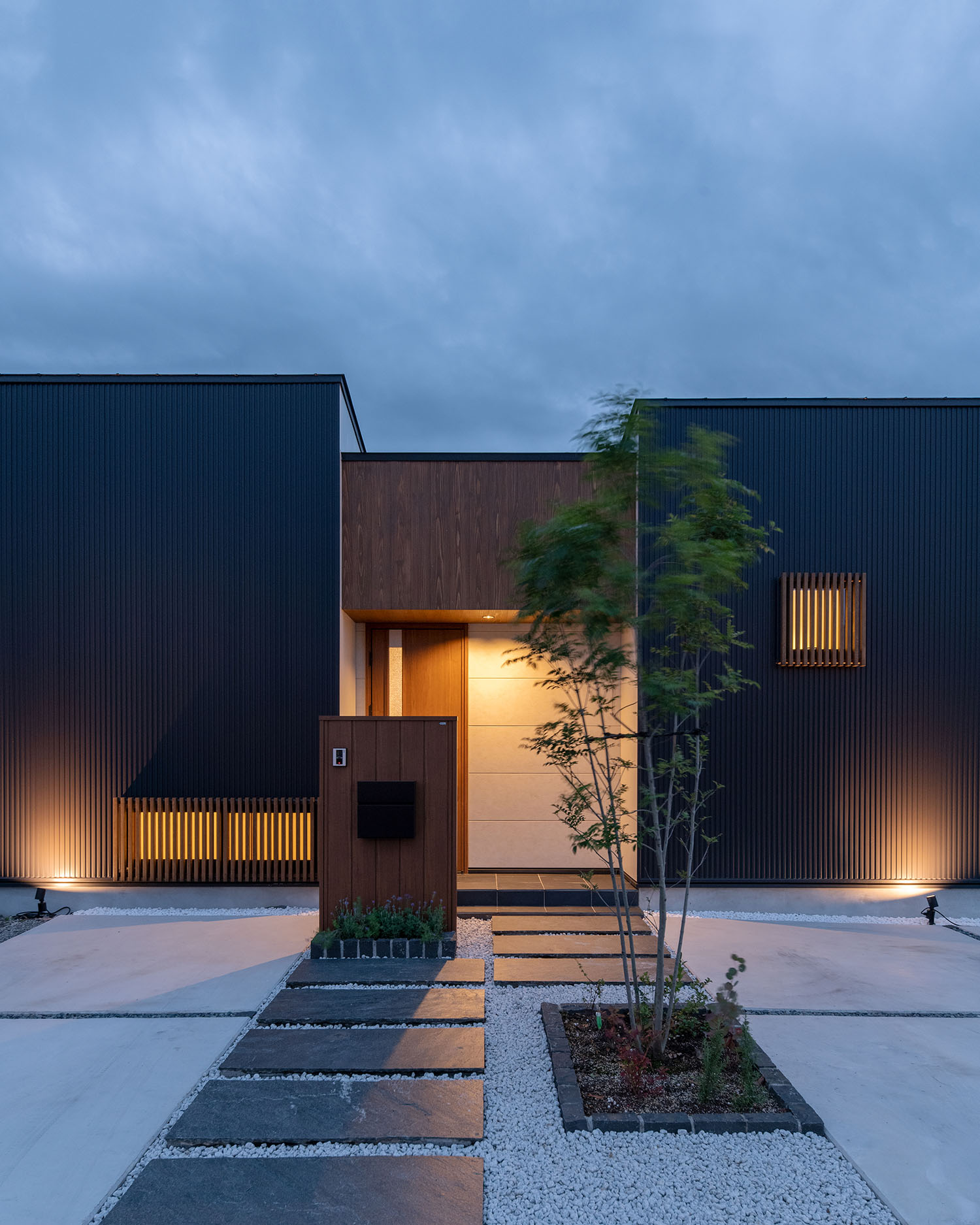 白い壁のエントランスが照明によって照らされる住宅・デザイン住宅 注文住宅・デザイン住宅建築実例_『CASE683 丘の上のハウス』_外観