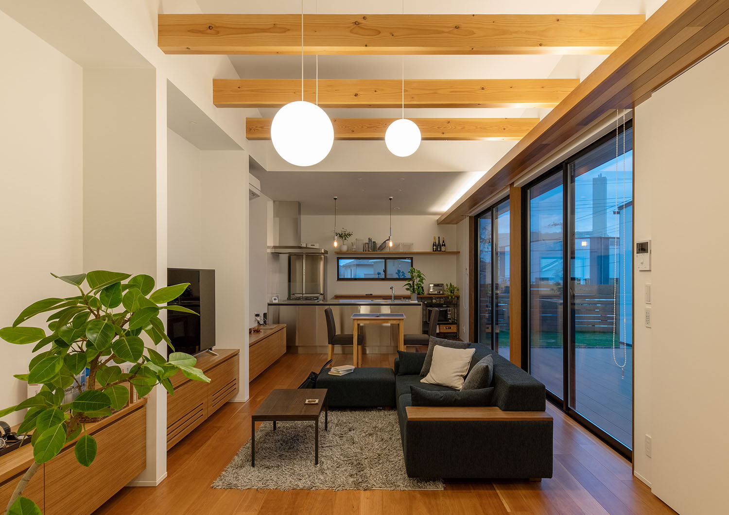 天井から吊り下げられたペンダントライトと、天井に仕込まれた間接照明に照らされるLDK・デザイン住宅 注文住宅・デザイン住宅建築実例_『CASE683 丘の上のハウス』_LDK