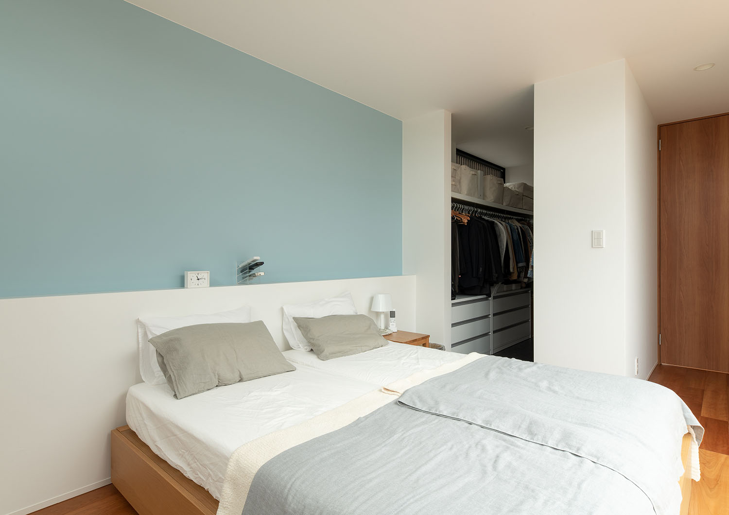 水色のアクセントクロスがあり、ウォークインクローゼットが繋がる寝室・デザイン住宅 注文住宅・デザイン住宅建築実例_『CASE683 丘の上のハウス』_寝室