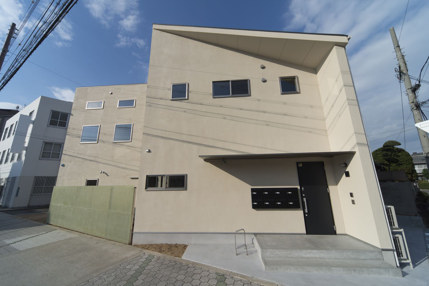 ベージュの外壁でシンプルな外観のアパート・デザイン住宅