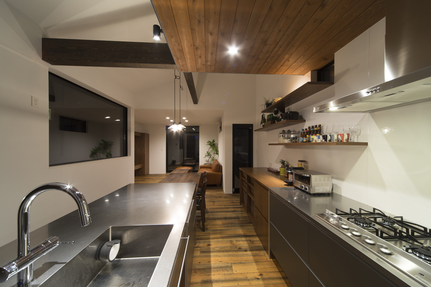 コンロとシンクが向かい合わせになった木の下がり天井のキッチン・デザイン住宅