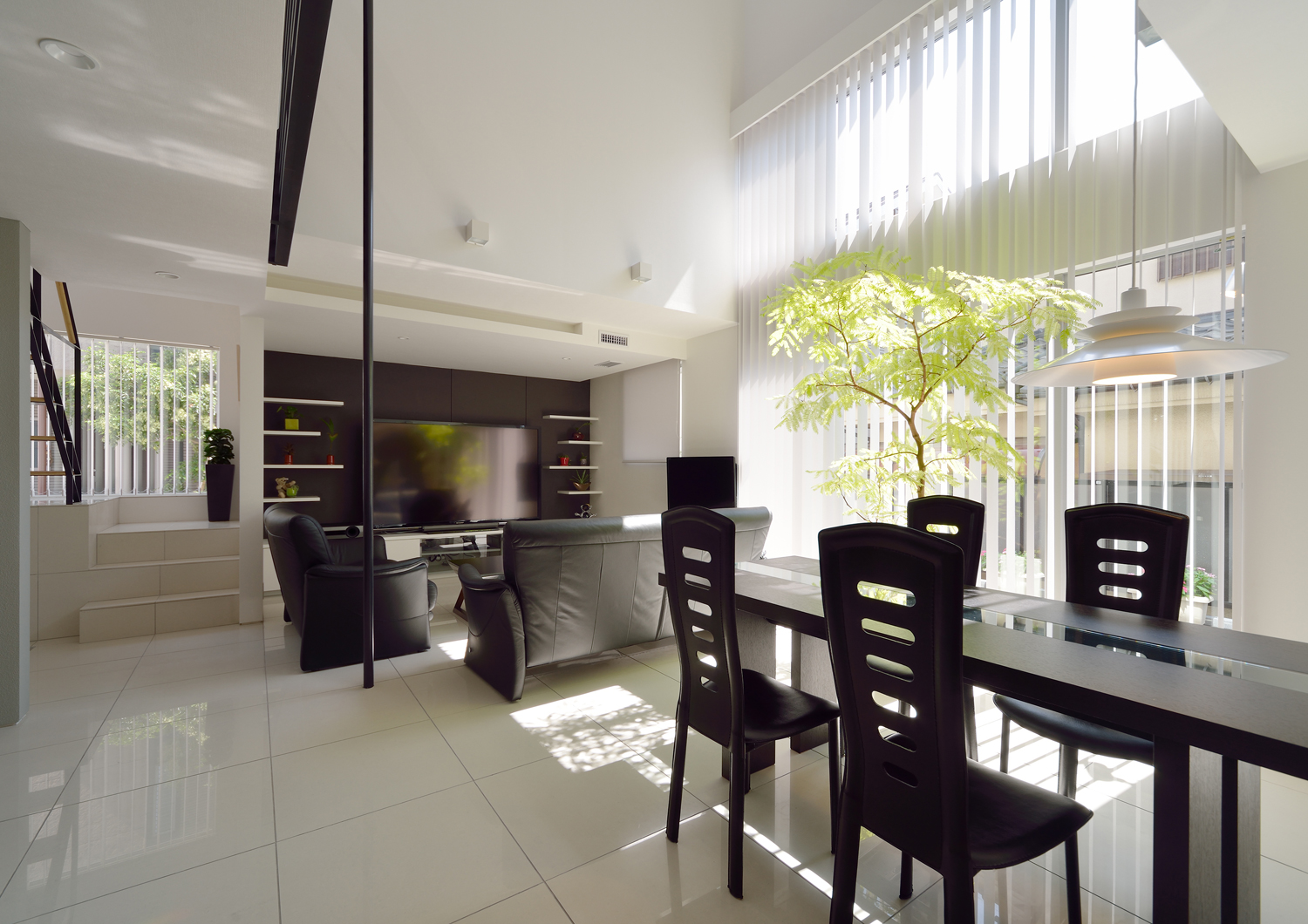 モノトーンでまとめた吹き抜けと大きな窓がある開放的な玄関・デザイン住宅