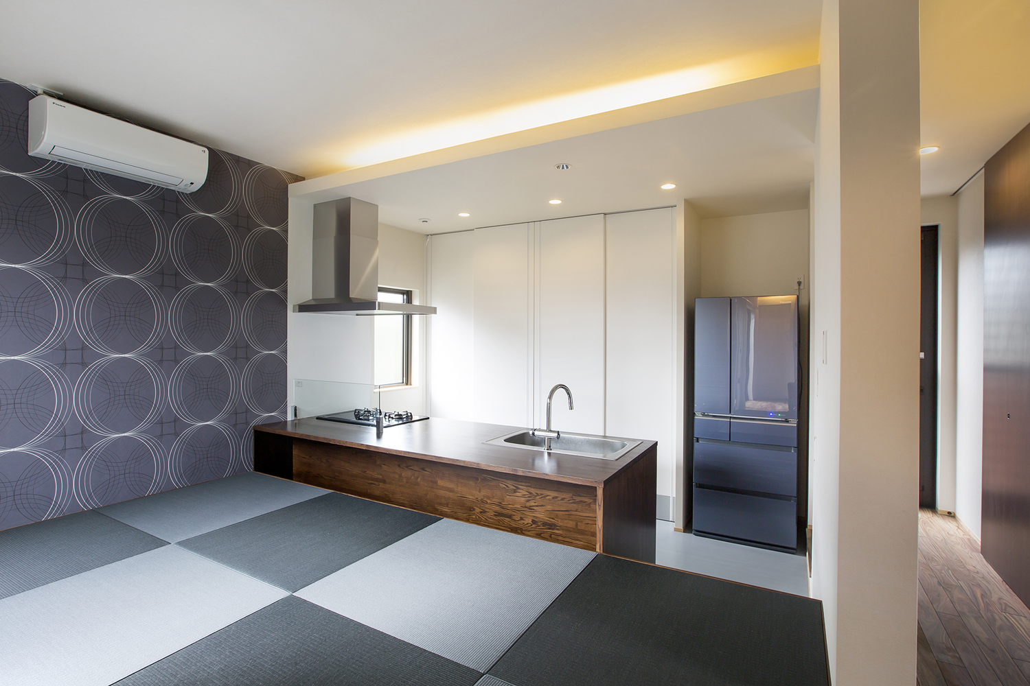キッチンの正面にあるモノトーンの琉球畳のスペース・デザイン住宅