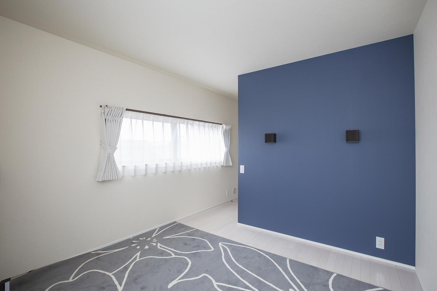 青いアクセントウォールのあるシンプルな寝室・デザイン住宅