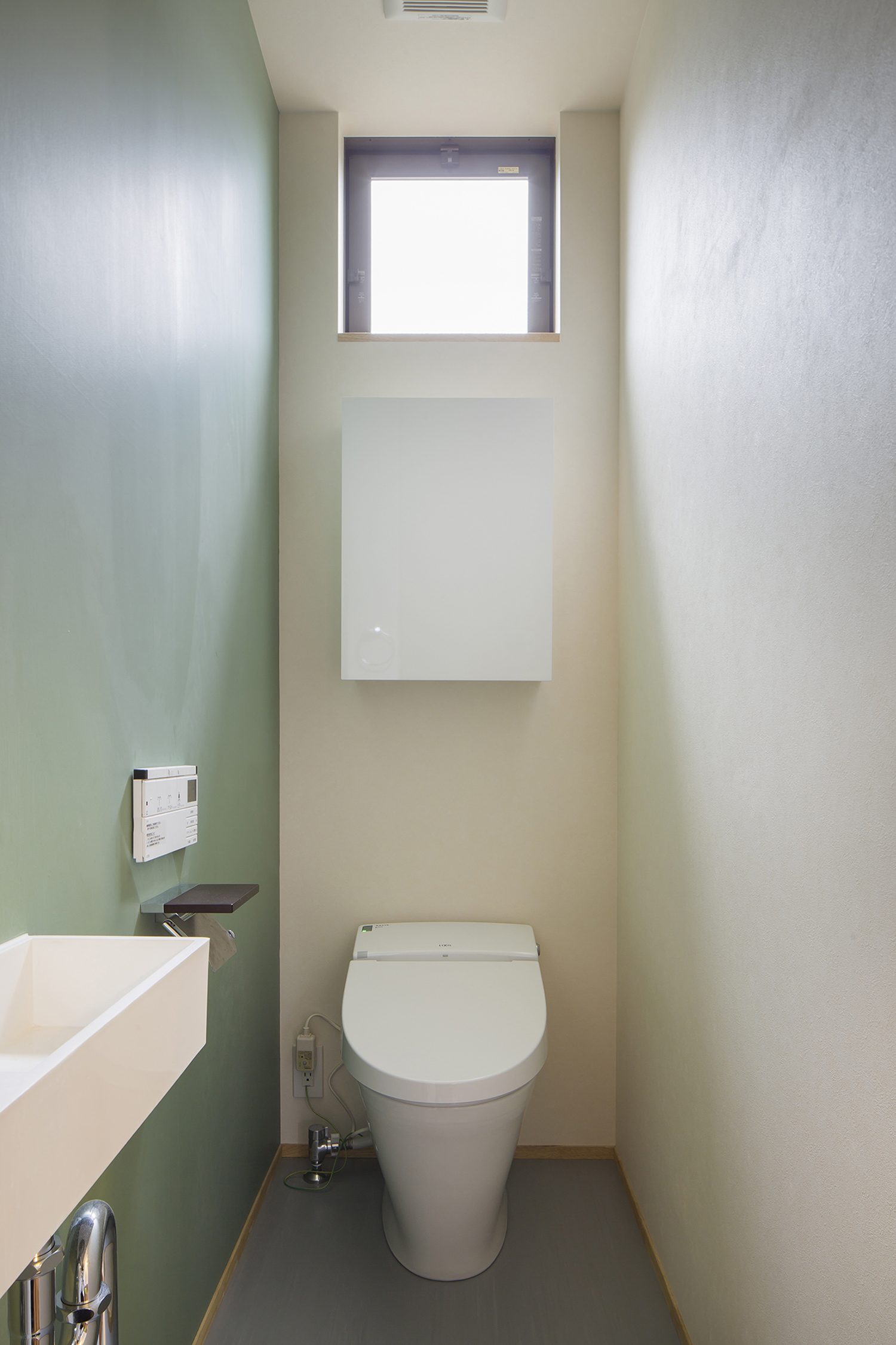 天井近くに正方形の窓を取り付けた薄型手洗いのあるトイレ・デザイン住宅