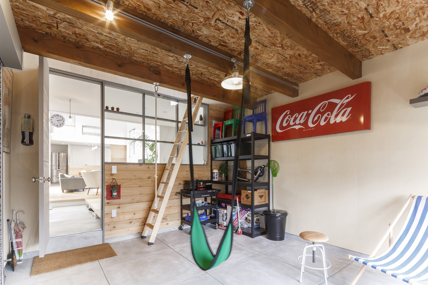 天井からハンモックが吊るされた明るく開放的なガレージ・デザイン住宅