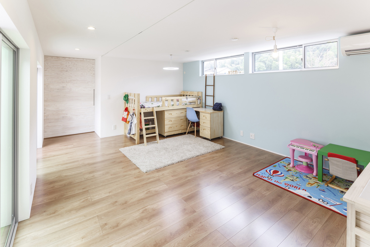 天井近くにスリット窓があるベッドや机を置いた子供部屋・デザイン住宅