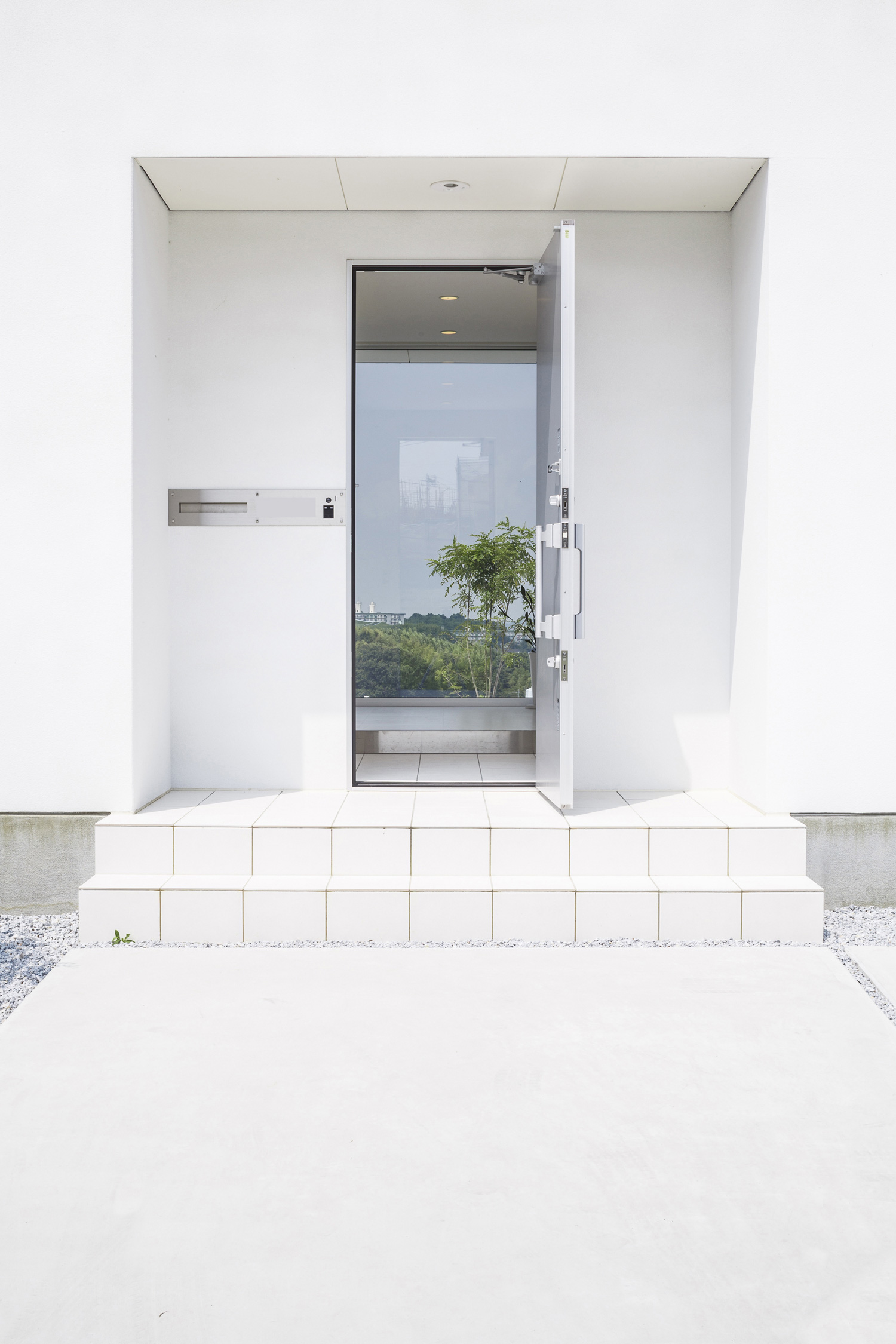 壁をくりぬいたような軒天井付きでシンプルな玄関ポーチ・デザイン住宅