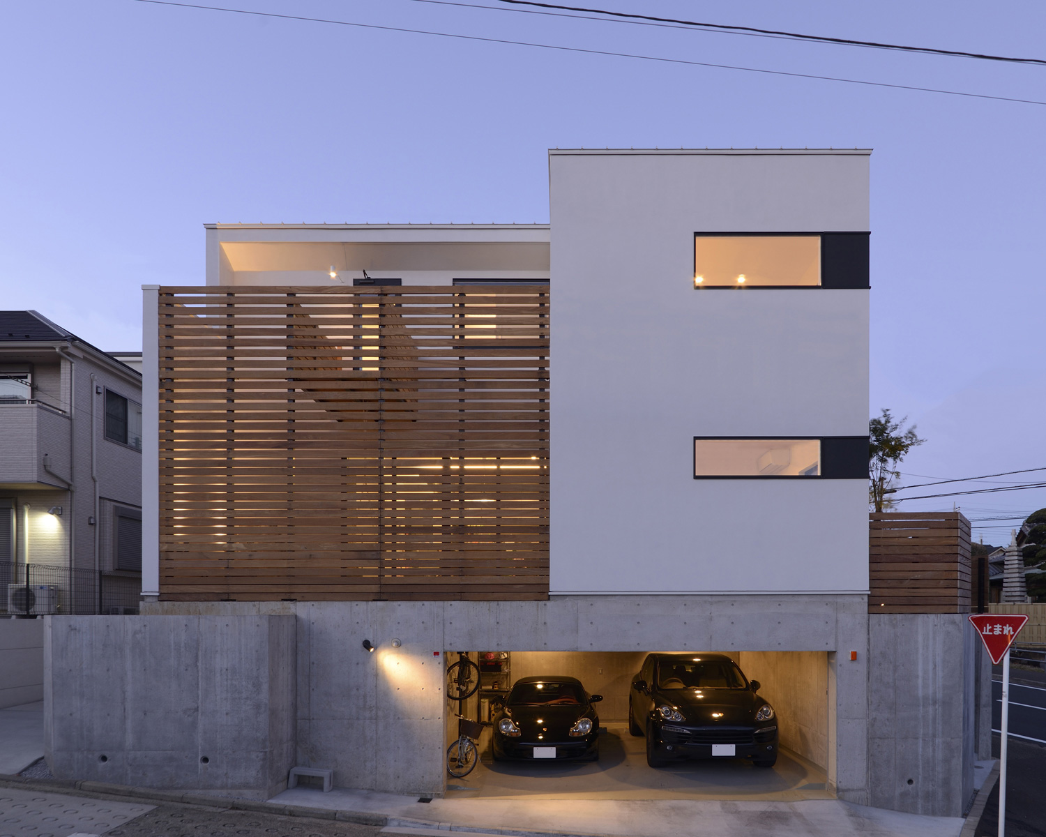 広い地下車庫がある白い外壁のスクエアな外観の家・デザイン住宅