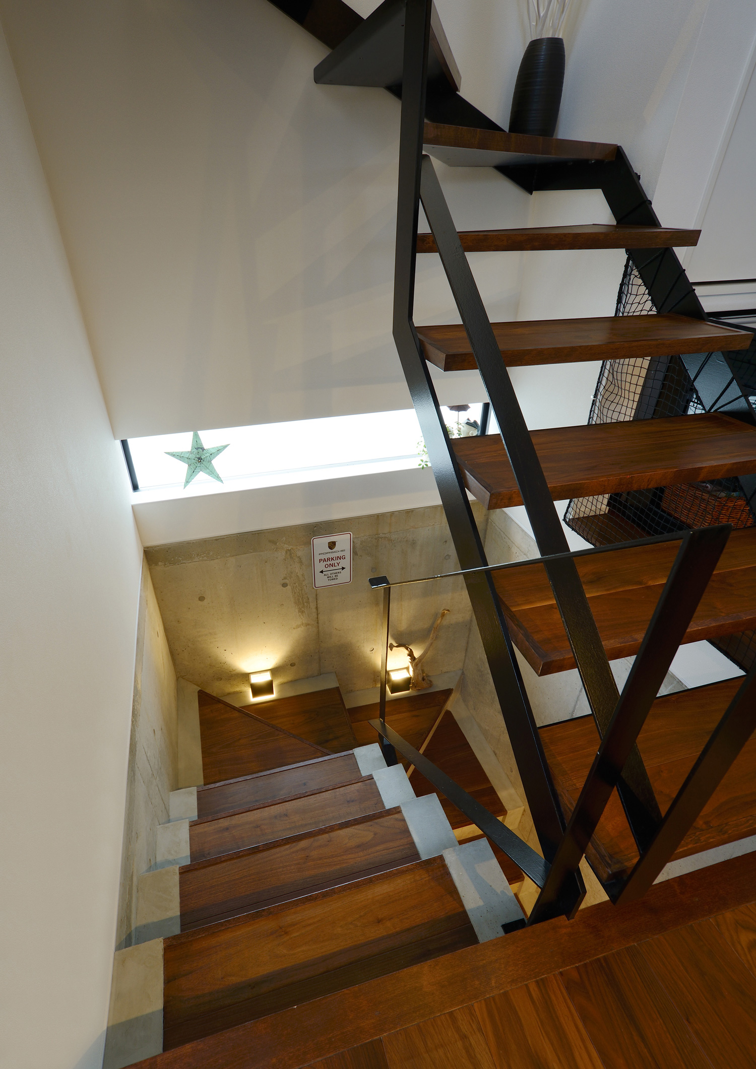 黒いアイアンの手すりを取り付けたフローリングと同じ色のスケルトン階段・デザイン住宅